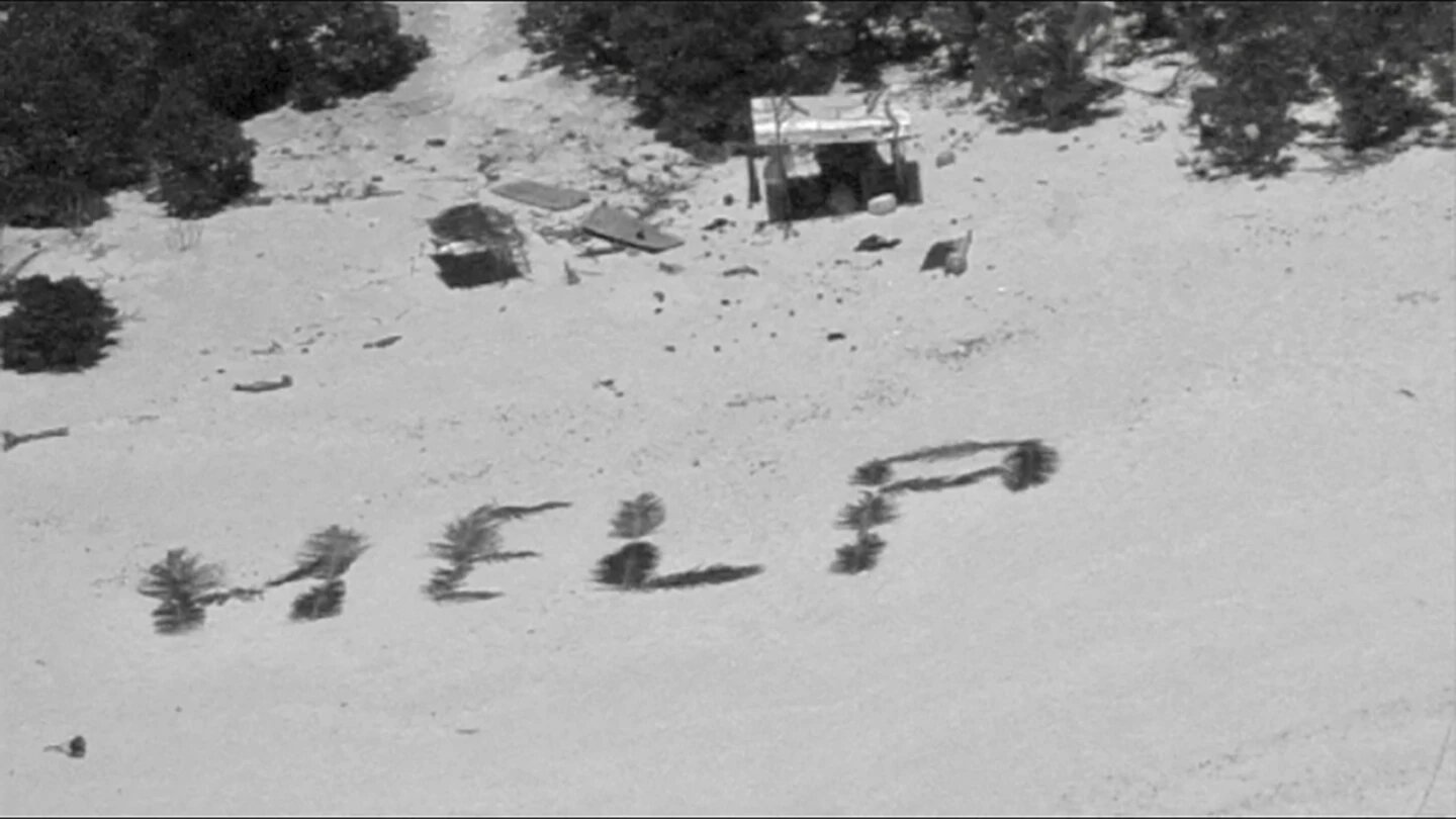 This photo provided by U.S. Coast Guard shows HELP" spelled out with palm fronds by three stranded mariners on Pikelot Atoll, Yap State, Federated States of Micronesia, Monday, April 8, 2024.