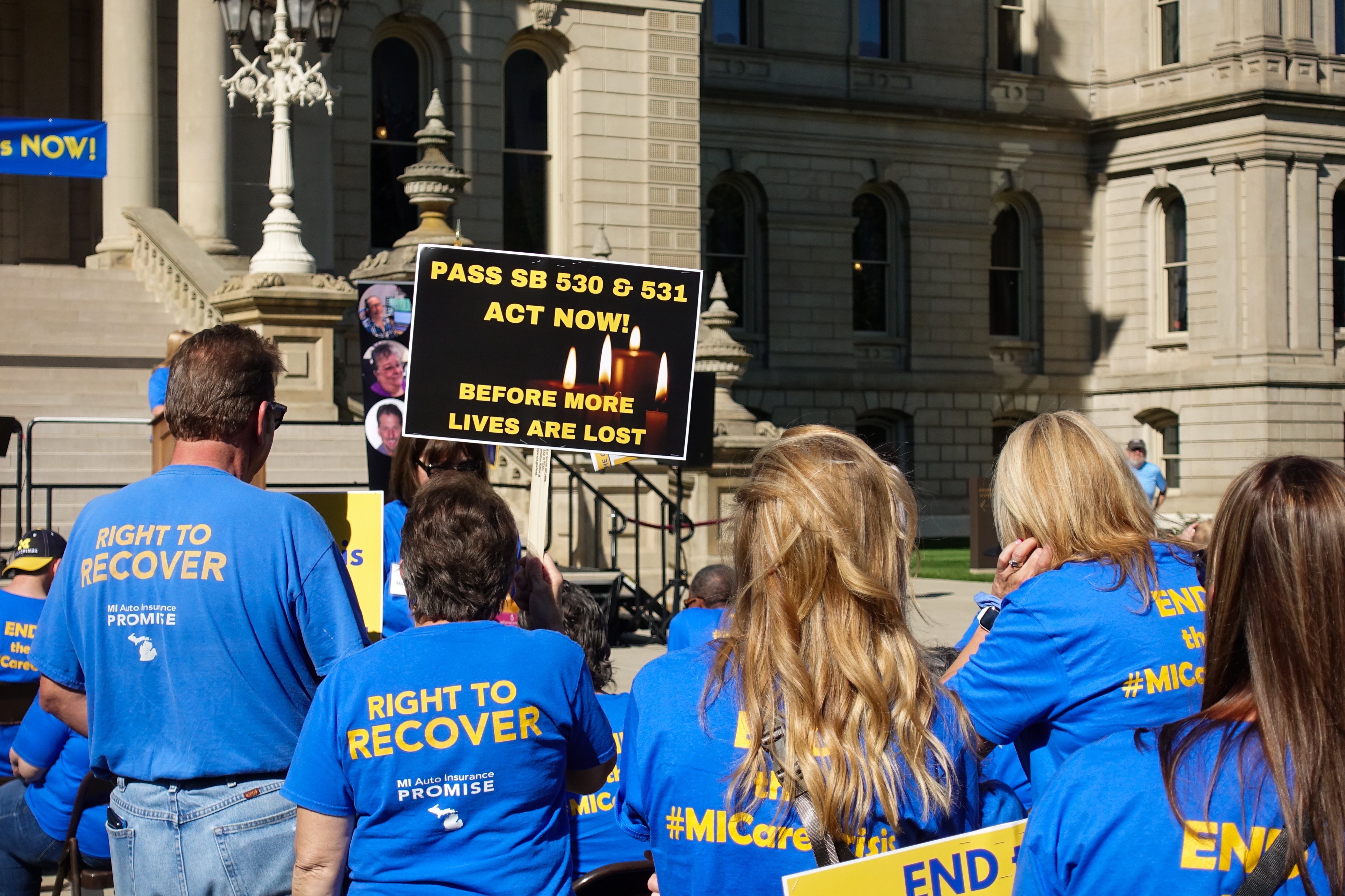 Attendees advocate for new legislation in a crowd of auto crash survivors and advocates at the Michigan Capitol on Oct. 3, 2023.