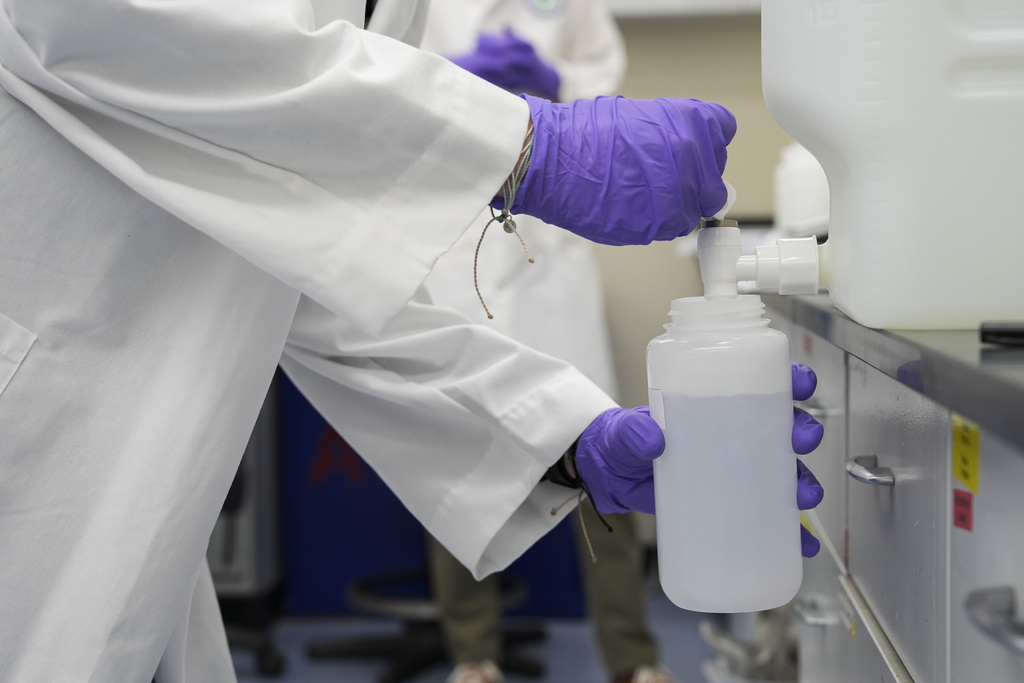 Logan Feeney pours a PFAS water sample into a container for research, Wednesday, April 10, 2024, at a U.S. Environmental Protection Agency lab in Cincinnati.