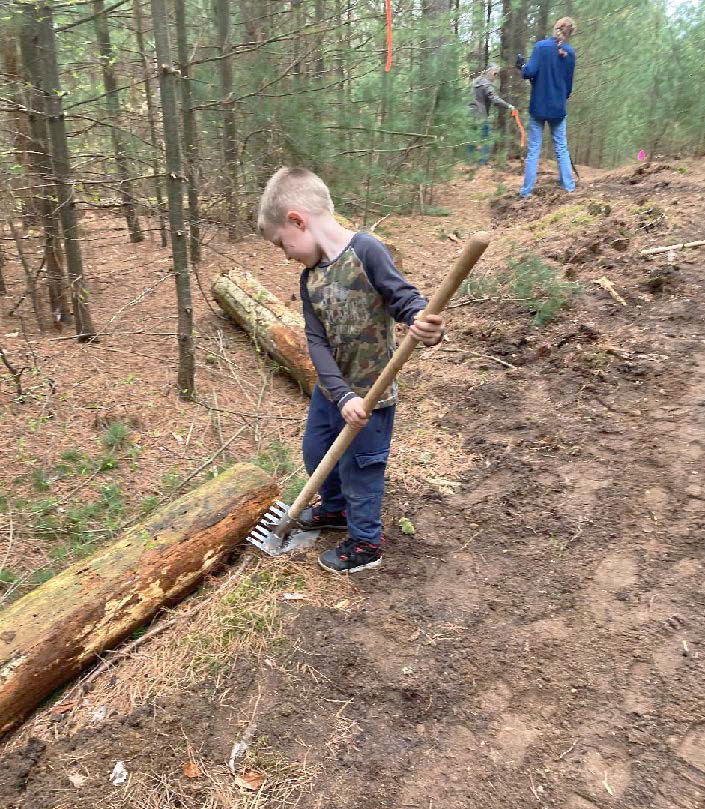 Buckley first-grader Miles Crumb is seen hard at work trail-building at Wheeler Creek, a 27-acre plot of forested land owned by Buckley Community Schools, on April 29. (Photo courtesy of Northwest Education Services)