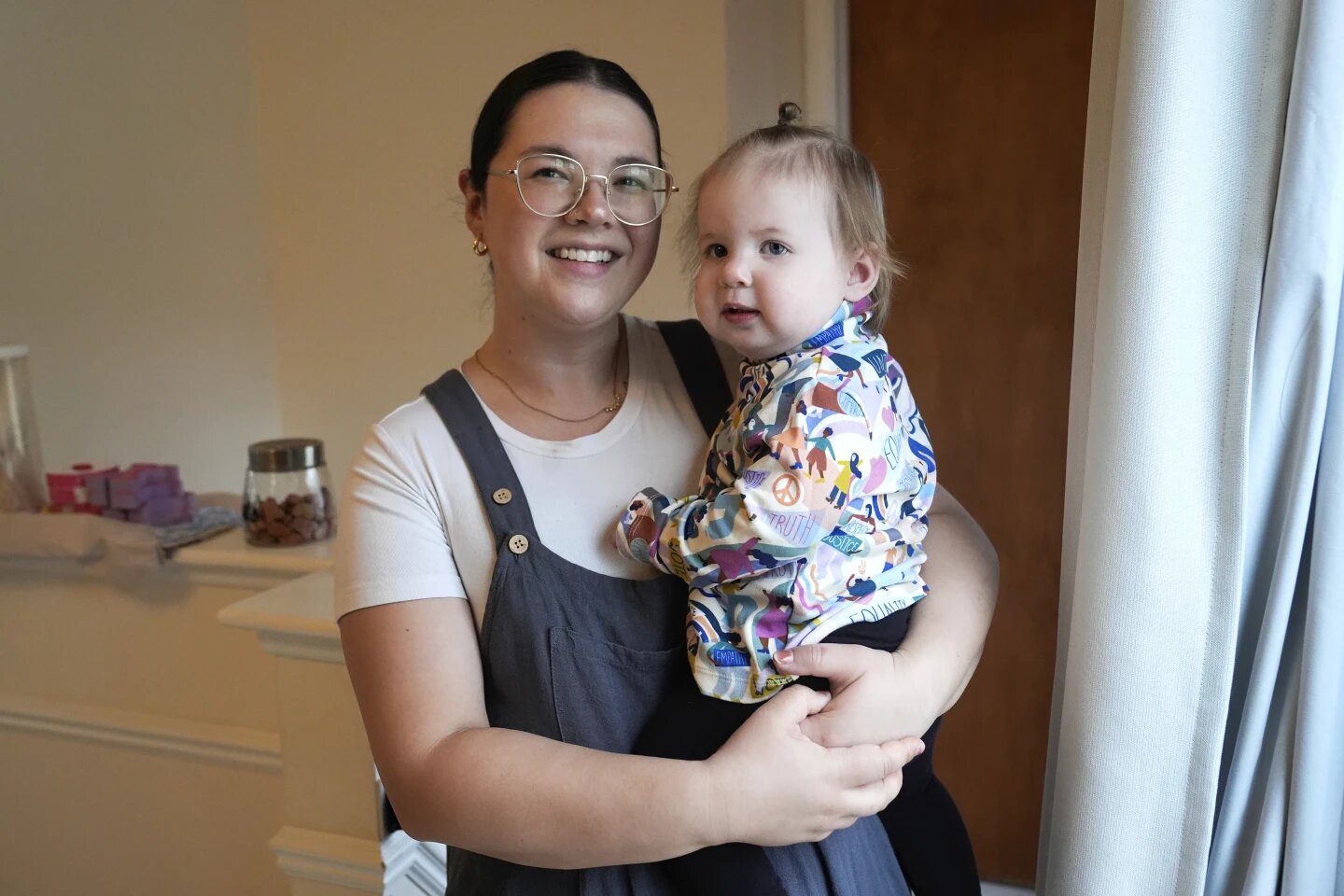 Rachael Lang poses with her daughter, Delaney, 1, in Livonia, Mich., Monday, March 18, 2024. Lang and her husband share DNA and a surname with their daughter, but have spent close to a year trying to adopt her because she was birthed by a surrogate.