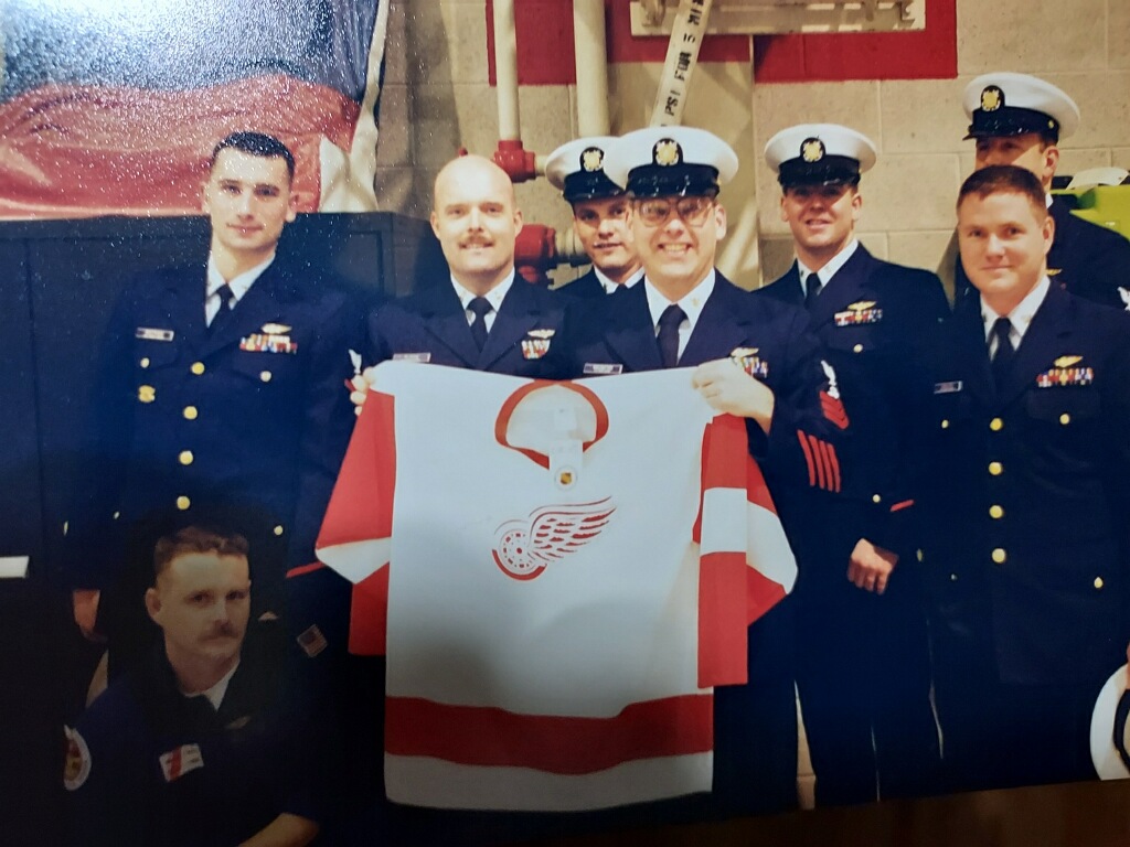 MacIntyre and fellow military servicemen pose with a Detroit Red Wings jersey.