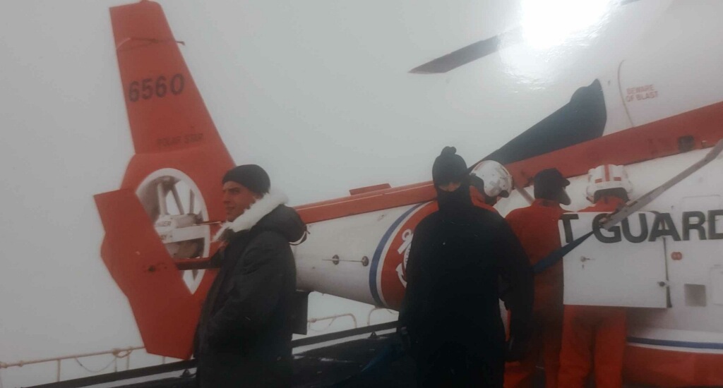 Rescue team members stand in front of a helicopter during MacIntyre's deployment in the Arctic in 1988.