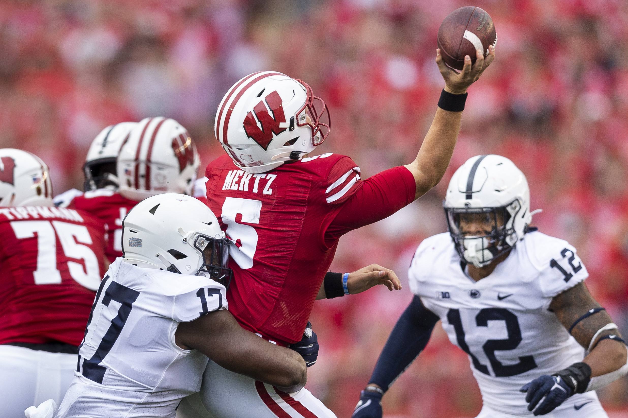 Ex-Badger Leo Chenal climbs parade bus during Super Bowl celebration