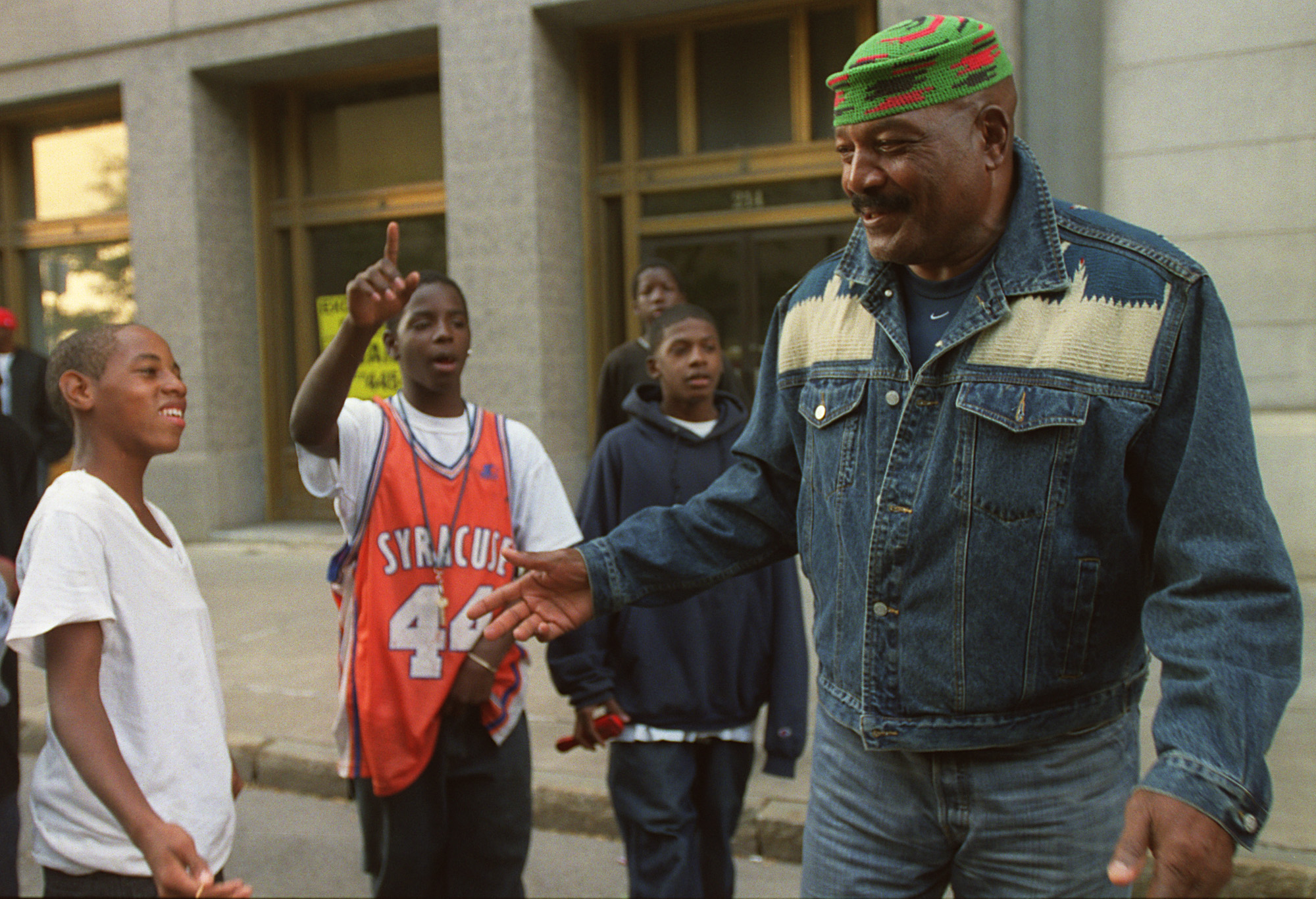 Football legend Jim Brown talks with a group of boys on Warren St. in Syracuse in 2002. Brown and renowned filmmaker Spike Lee addressed a group of local community leaders and youth about the prospect of bringing a program that works with ex-convicts to Syracuse. Brown and Lee are in town for the presentation of Lee's film "Jim Brown;All-American."