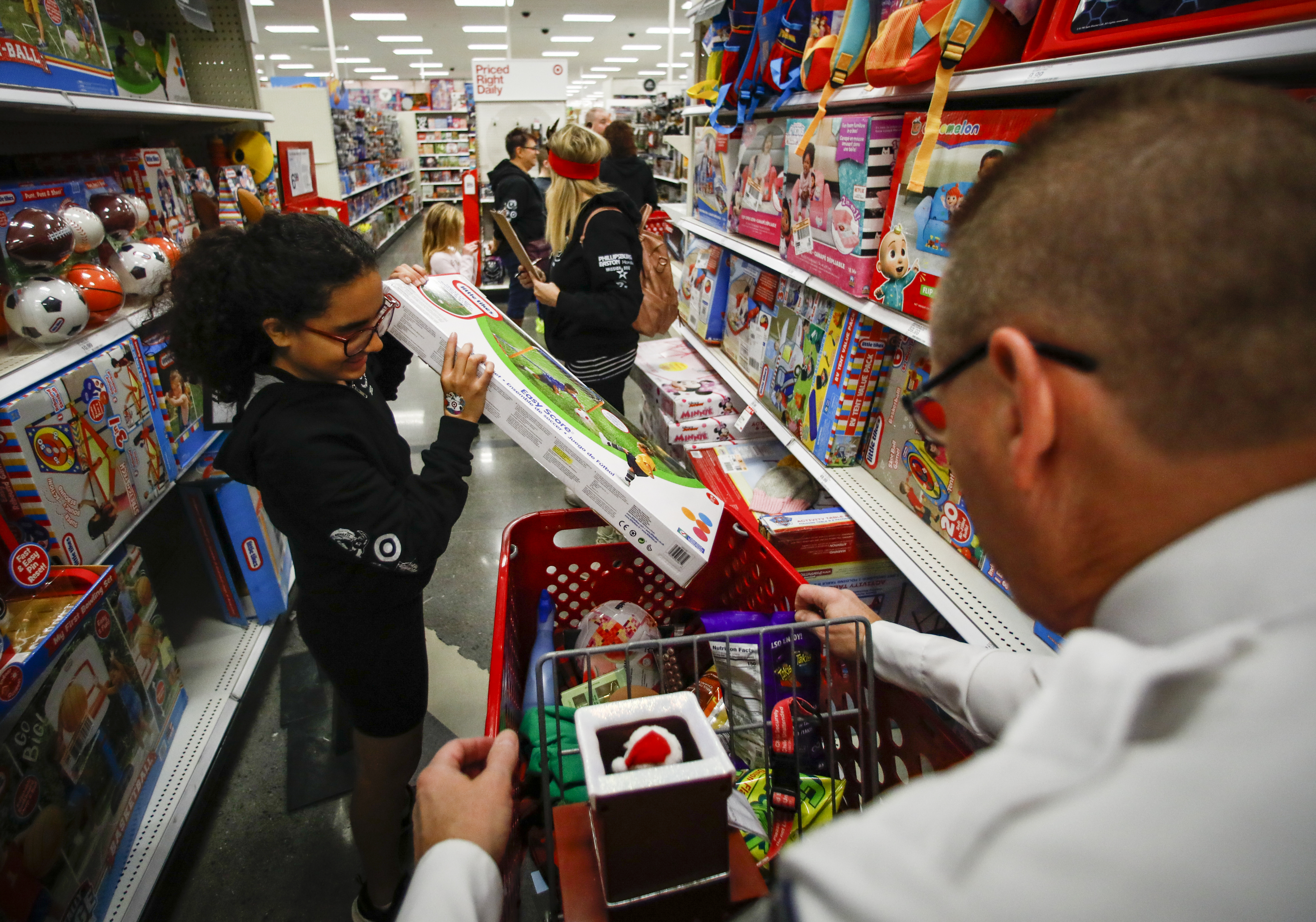 Aniya Bermudez, 12, selects an item to buy as Chief Timothy Koder, right, waits with her cart. She was among 22 children and their families from the Catasauqua Area School District who were accompanied by Lehigh-Northampton Airport Authority Police Department during the shopping spree Saturday, Dec. 3, 2022, at Target in Hanover Township, Lehigh County. 