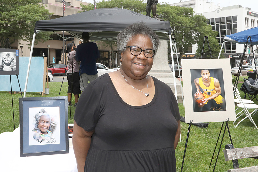 Denise Stewart show some of her photography at Chalk for Change 2022 taking place at Court Square in Springfield on July 16th. (Ed Cohen Photo)