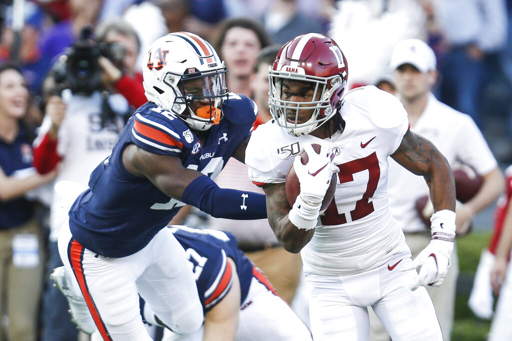 FILE - In this Saturday, Sept. 26, 2020, file photo, Alabama wide receiver Jaylen  Waddle, center, pulls down a reception between Missouri's Tyree Gillespie,  right, and Ishmael Burdine, left, during the first