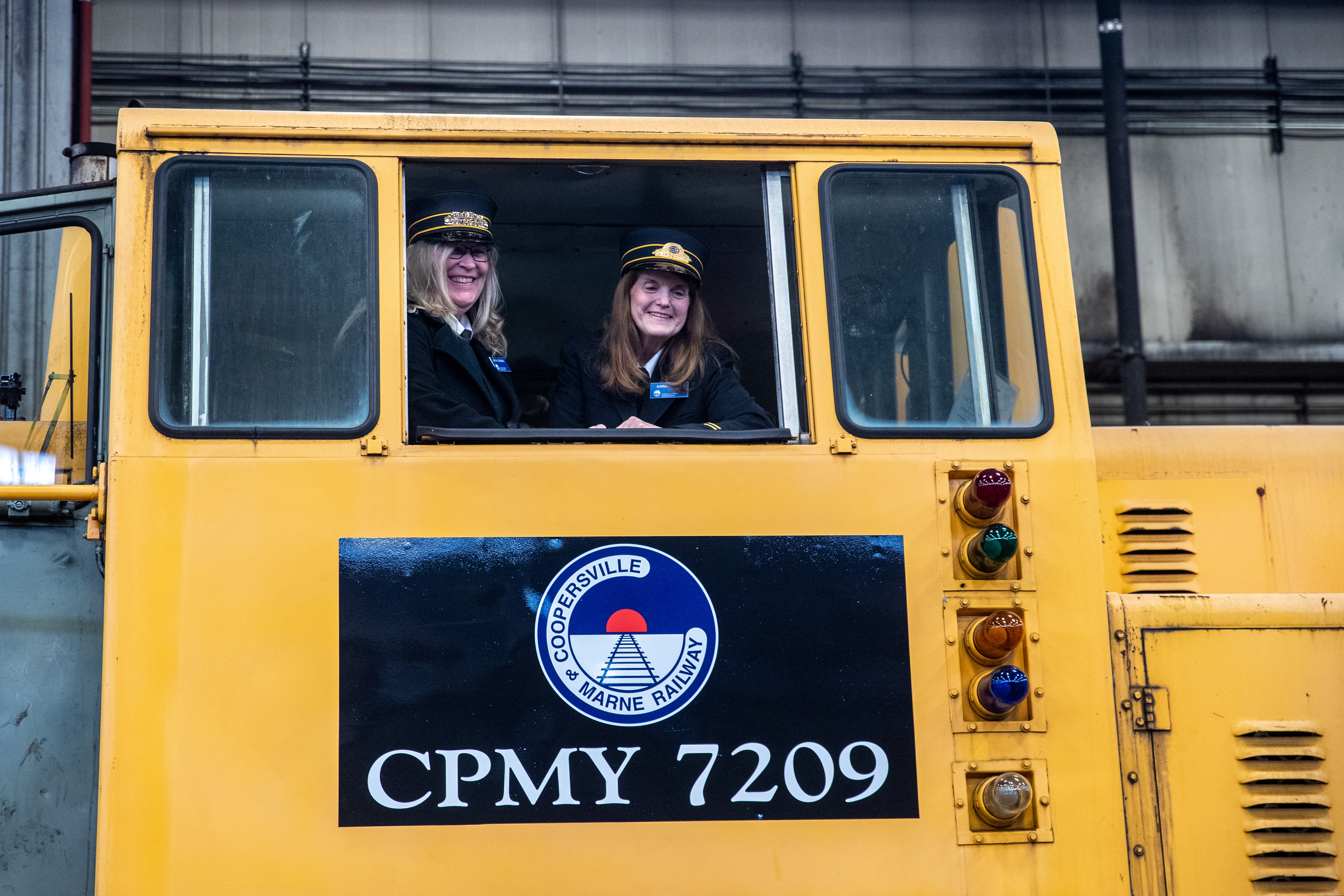 Kathy Jenkins, left, and Karin Bowden, both from the Coopersville and Marne Railway, look out from a 1979 GE diesel train locomotive at the Consumers Energy J.H. Campbell plant in Port Sheldon Township on Monday, Feb. 13, 2023. Consumers Energy is donating the locomotive to the railway. (Cory Morse | MLive.com)