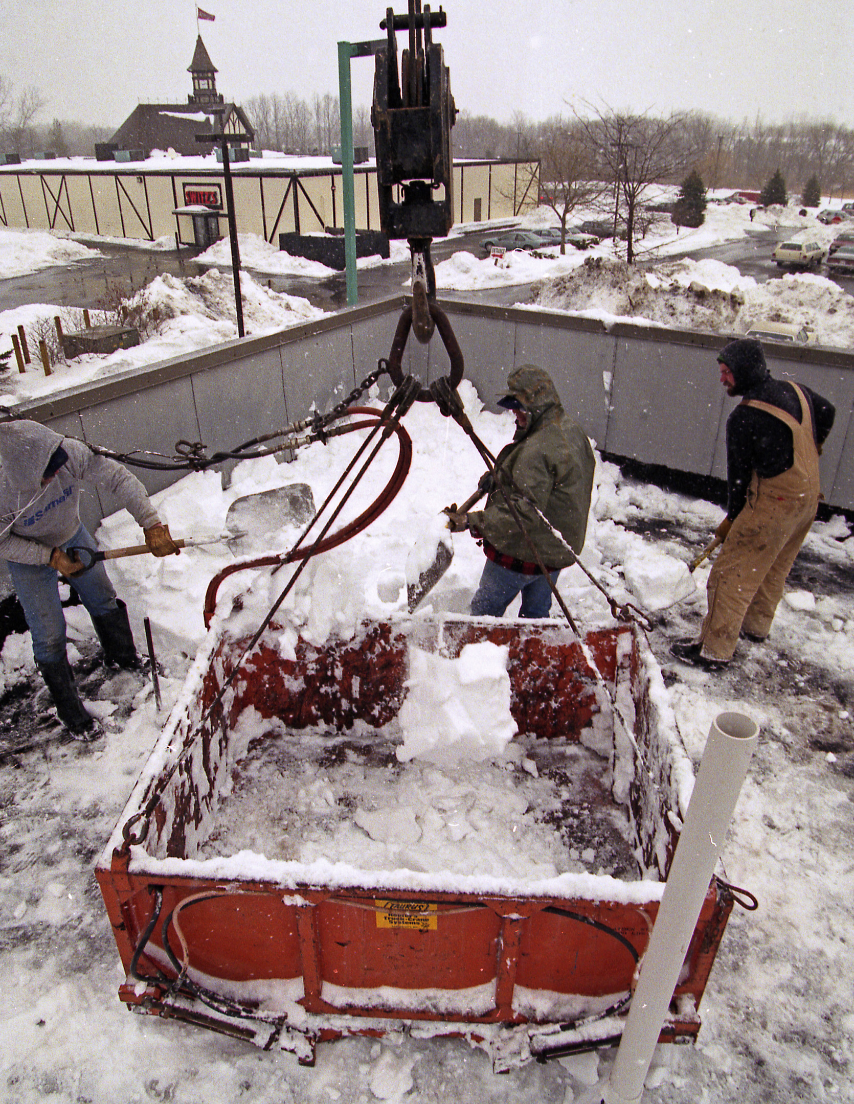 Ron Haney, Dennis Therrien and Dave Bean of Josall Roofing, using a crane to get snow off roof of Denny's Restaurant on South Bay Road, North Syracuse following the Blizzard of '93.