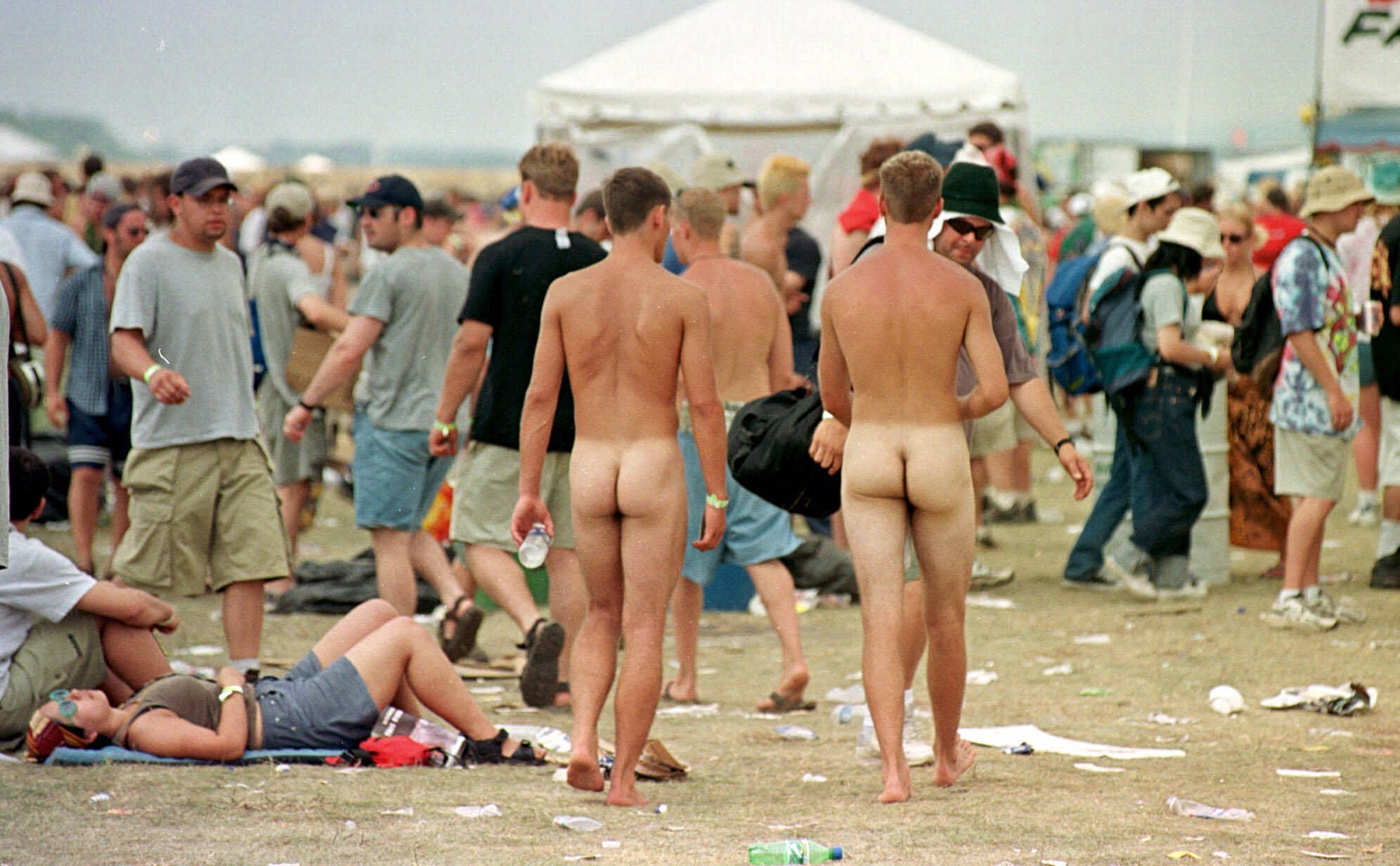 Two naked men stroll through the grounds of Woodstock '99 on the forme...