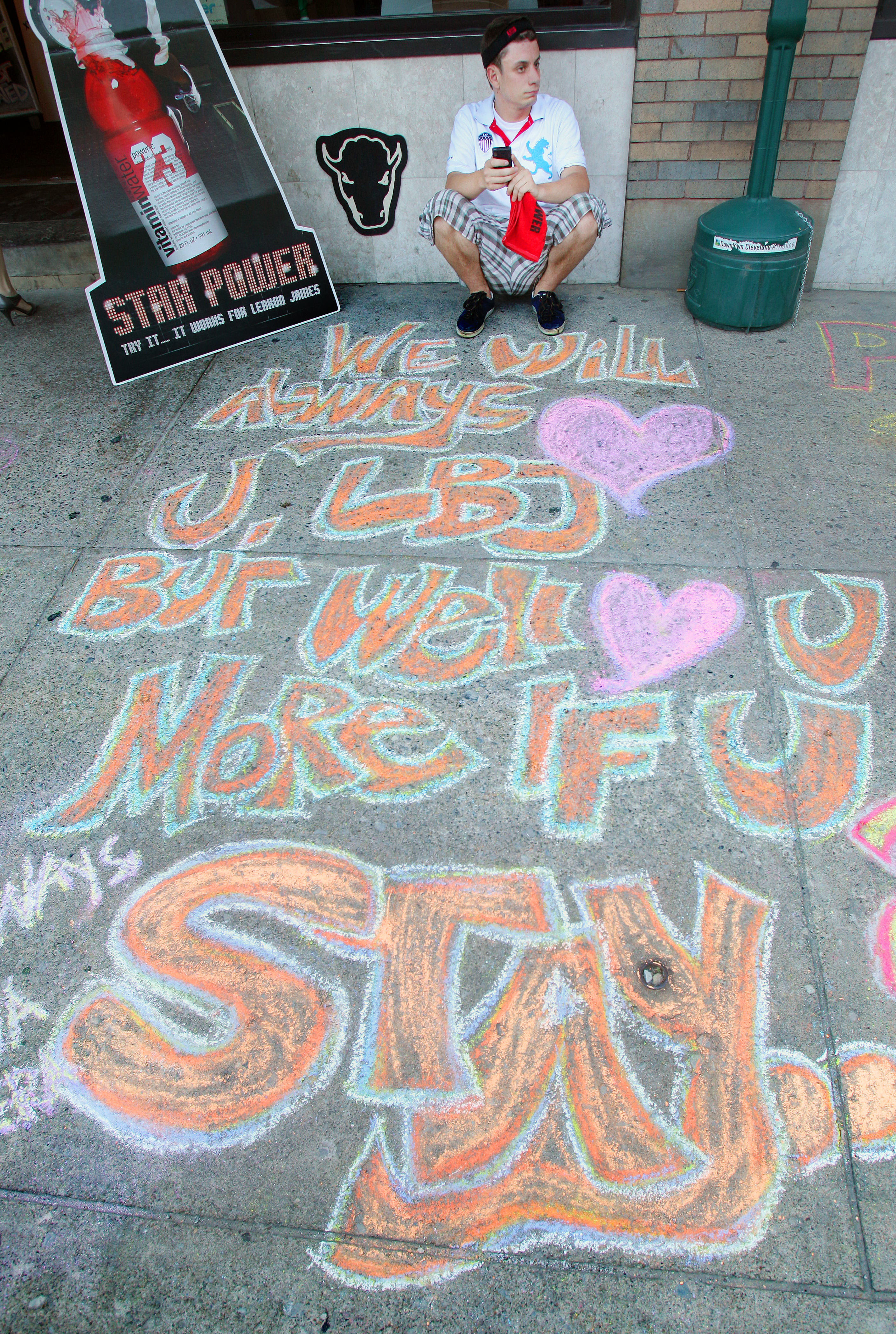 Michael Joseph of Solon waits for the LeBron James announcement of where he will play next year outside the Harry Buffalo restaurant in Cleveland July 8, 2010 by a chalk writing that a Cleveland Cavaliers fan wrote hoping LeBron stays in Cleveland.  (John Kuntz / The Plain Dealer) 