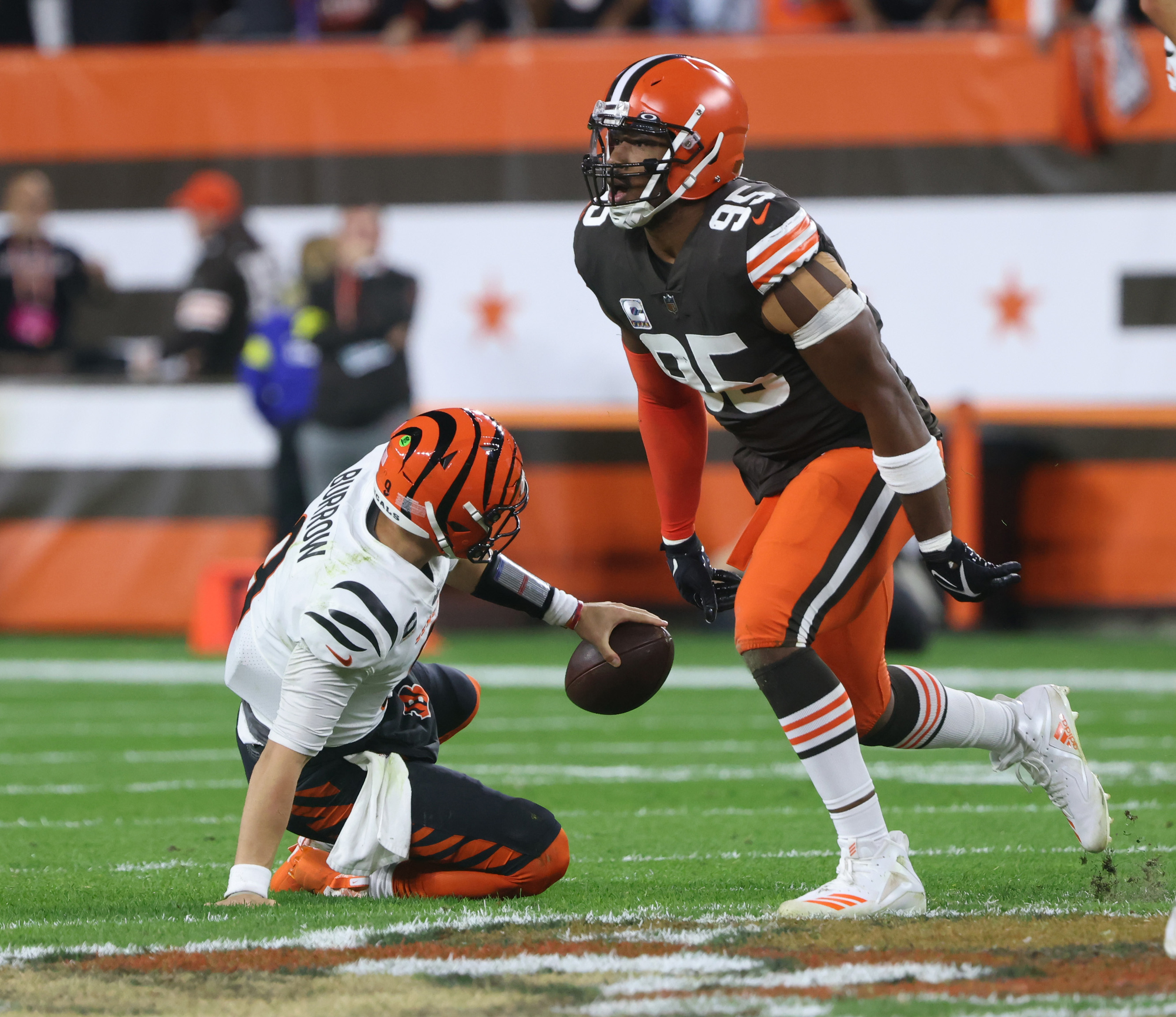 Cincinnati Bengals quarterback Joe Burrow (9) is pressured by and sacked by  Cleveland Browns defensive end