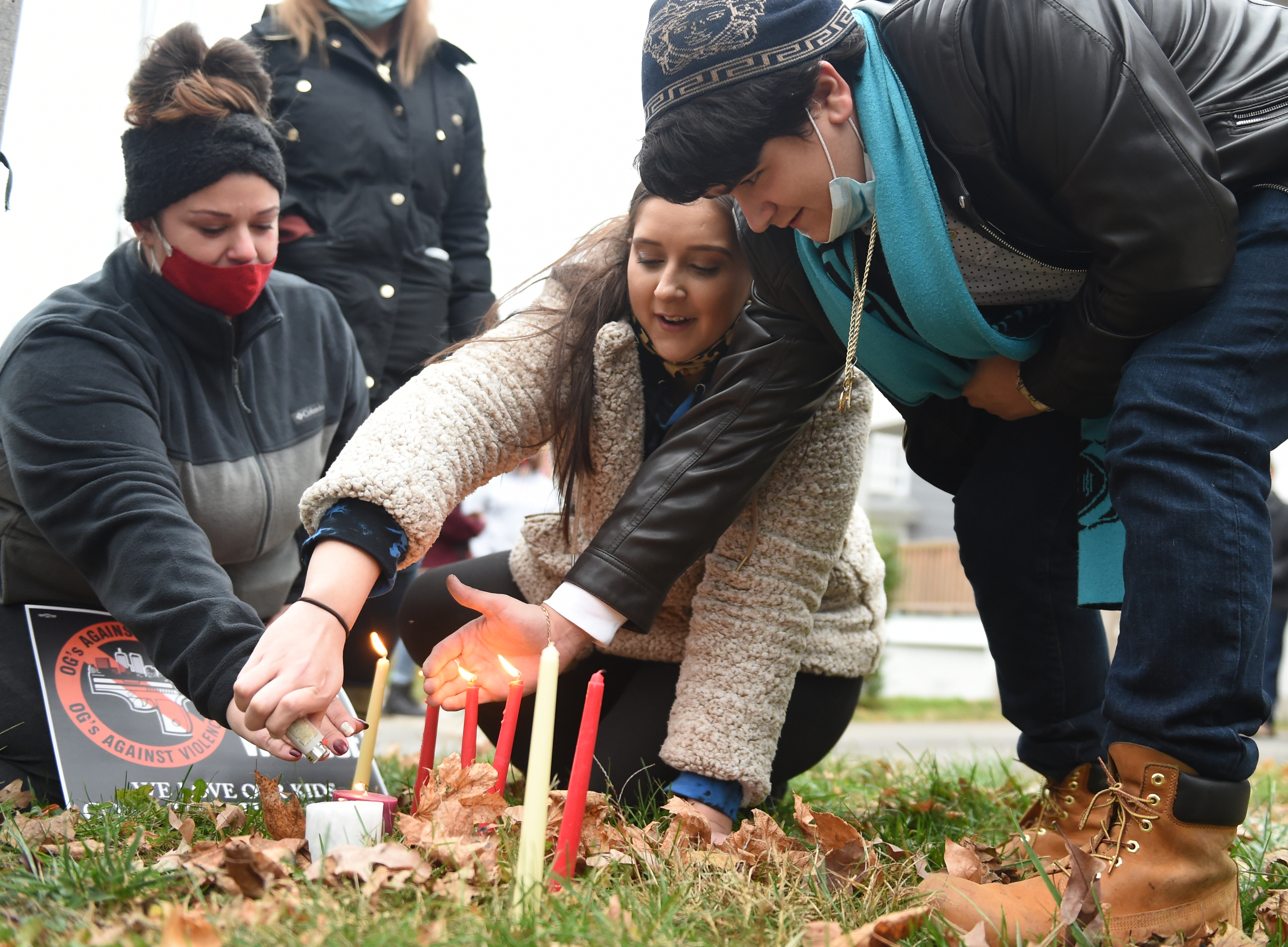 Cousin Briana Edwards, left, girlfriend Sydney Talarico, center, and friend Christian Talarico light candles to remember Jerry Murray who was murdered Wednesday November 9th, Judson Street, Syracuse, N.Y., Saturday, November 21, 2020.