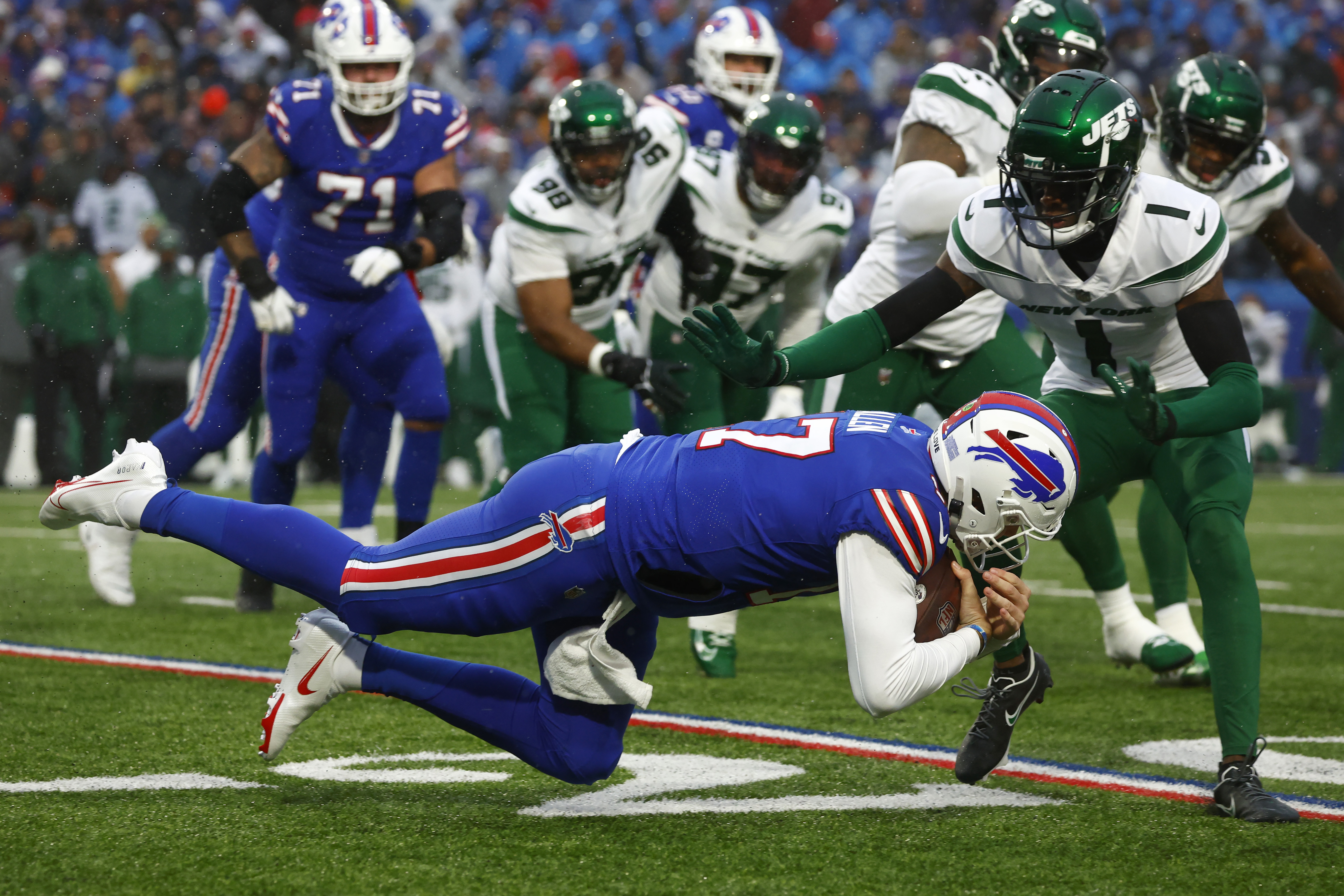 New York Jets running back Michael Carter (32) is brought down by Buffalo  Bills cornerback Taron Johnson (7) during the first half of an NFL football  game, Sunday, Dec. 11, 2022, in