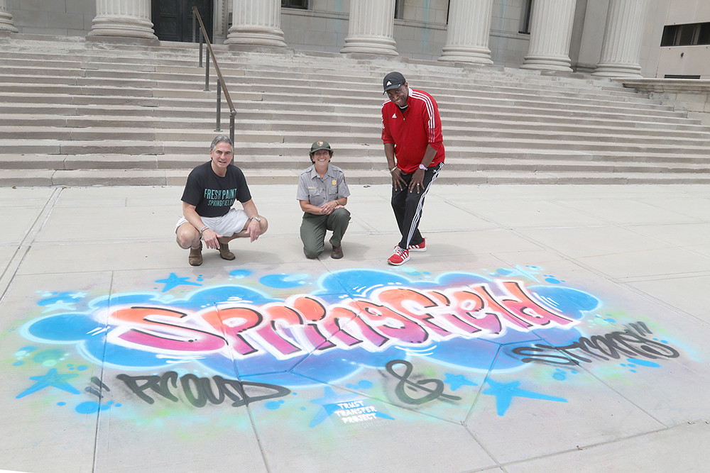 Springfield Mayor Domenic Sarno, Springfield Armory National Historic Park Superintendent Kelly Fellner, and Springfield Cultural Council President Andrew Cade at the chalk drawing in front of Springfield City Hall at Chalk for Change 2022 taking place at Court Square in Springfield on July 16th. (Ed Cohen Photo)