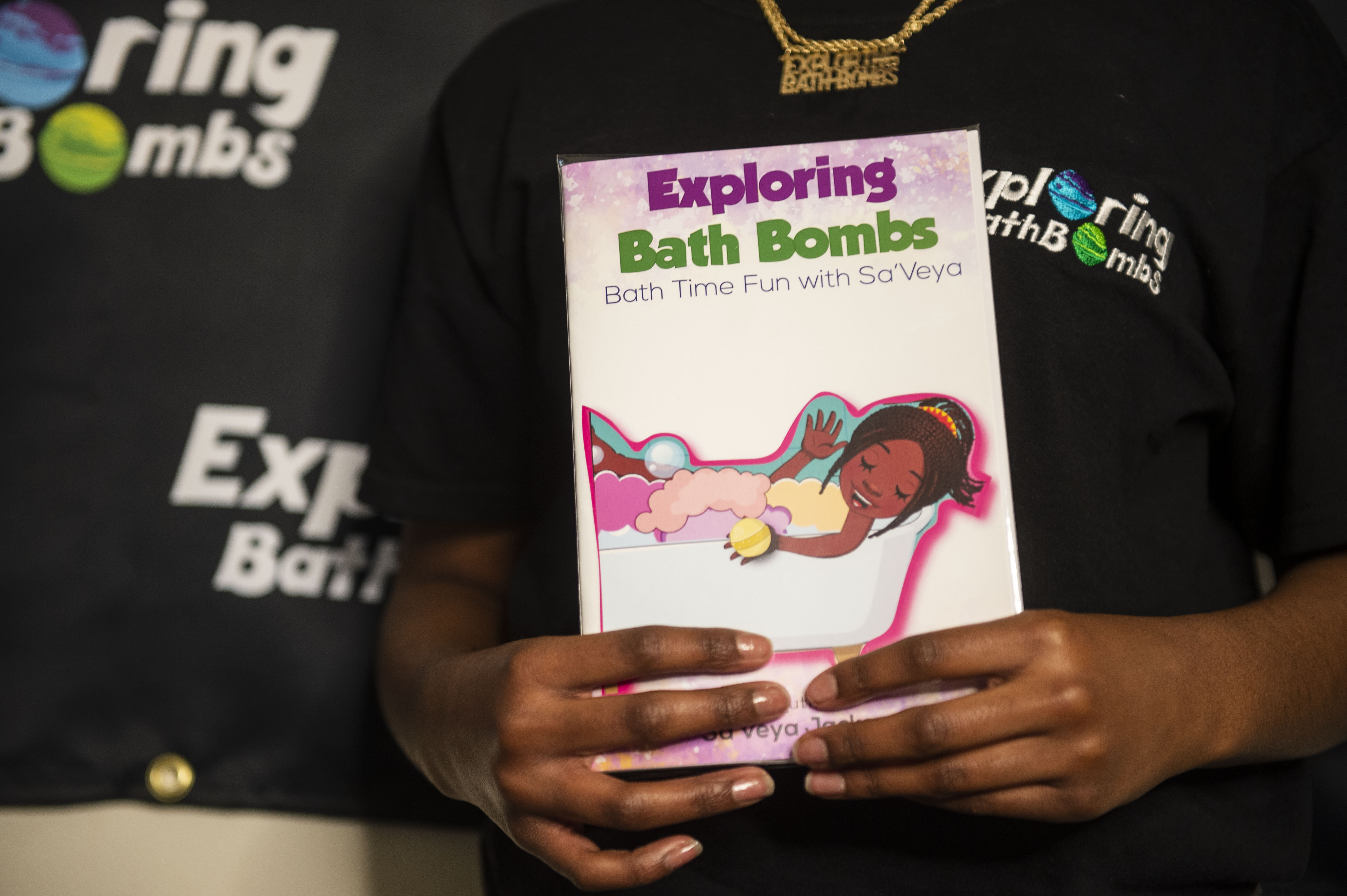 Sa'Veya Jackson, 11, holds one of the books she wrote for her business Exploring Bath Bombs on Thursday, April 22, 2021. (Kaytie Boomer | MLive.com)