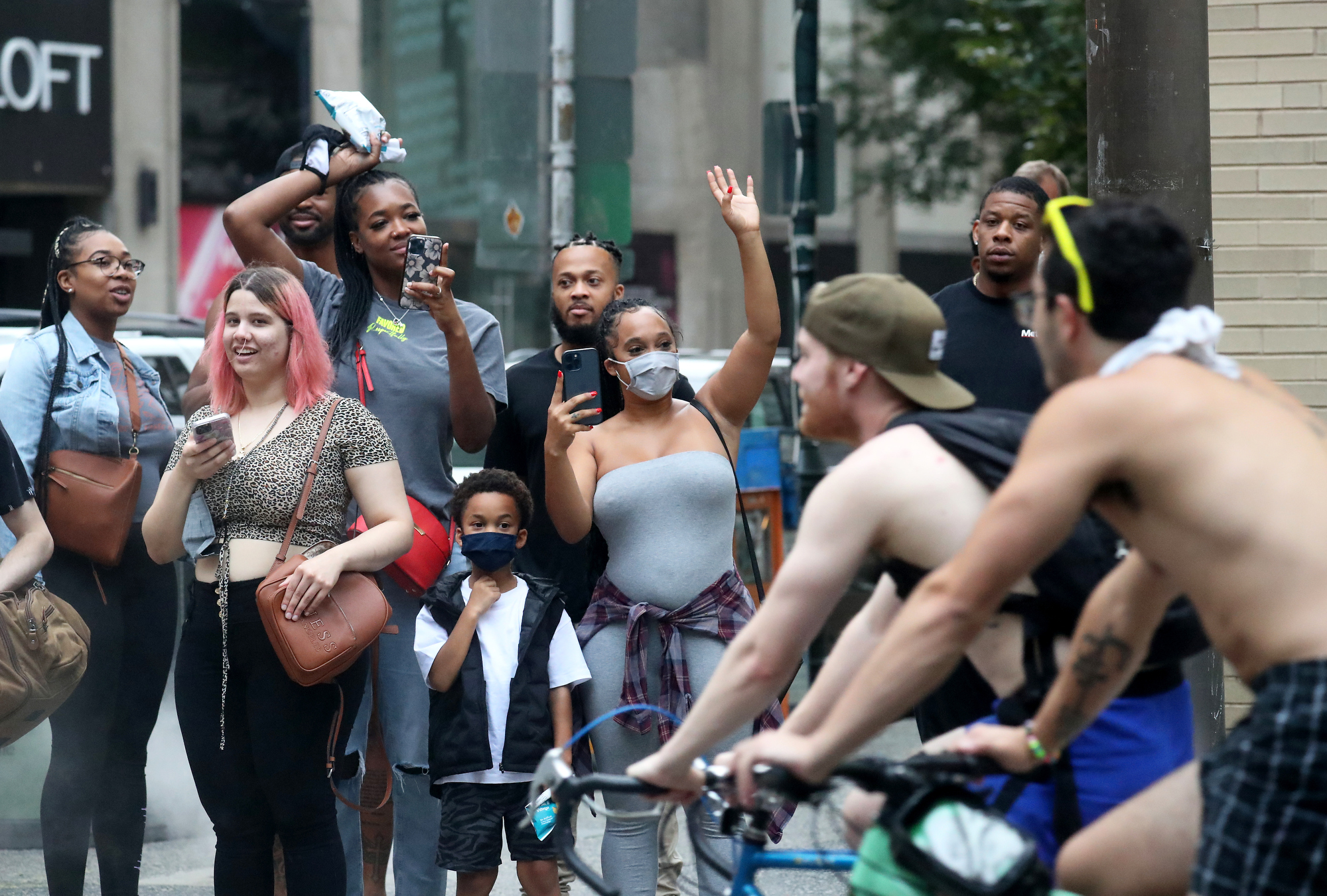 People watch and record participants in the the Philly Naked Bike Ride at Rittenhouse Square in Philadelphia Saturday, Aug. 28, 2021.