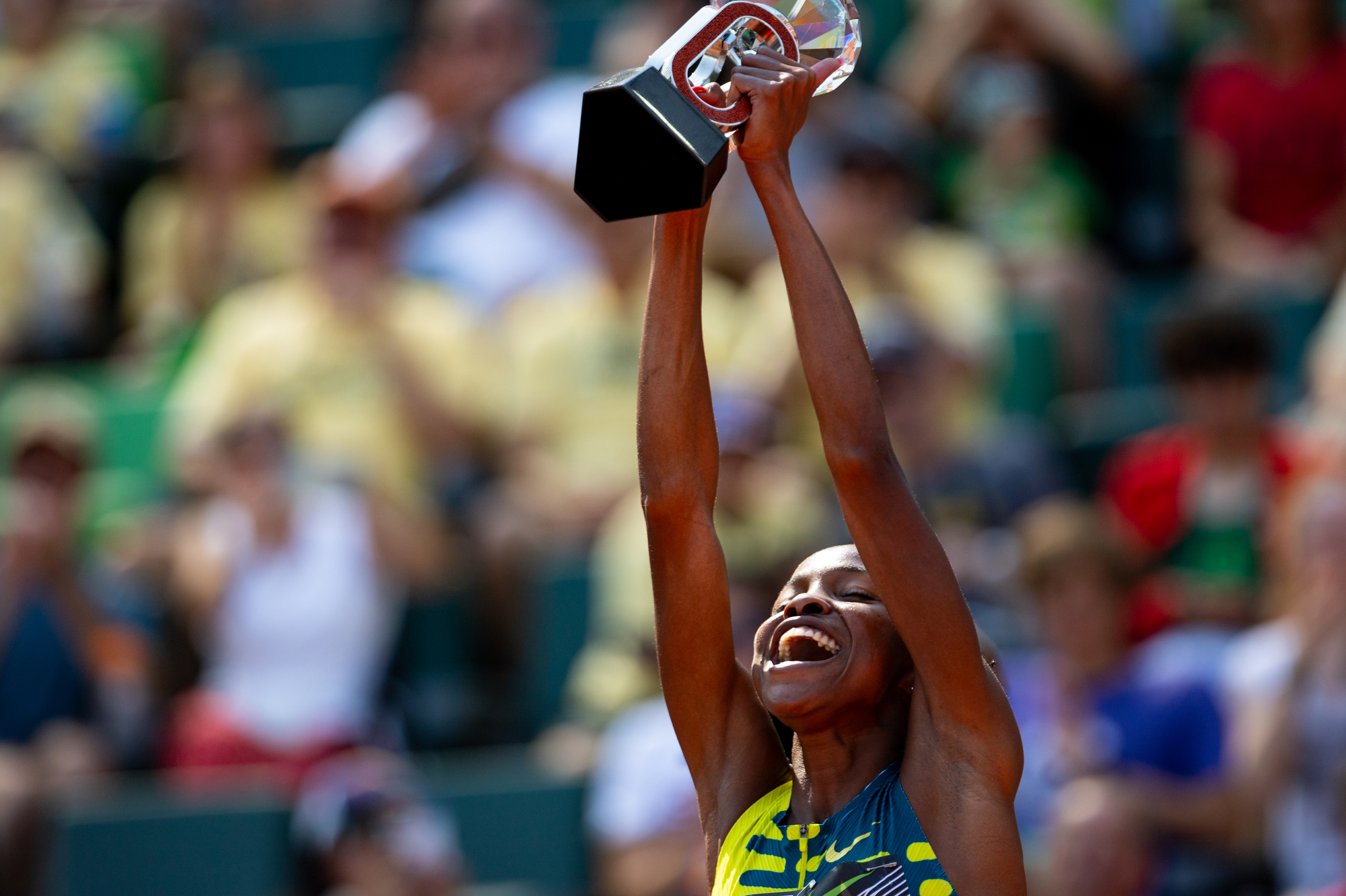 Winfred Mutile Yavi of Bahrain holds up the Diamond League trophy after winning the women's steeplechase at the Prefontaine Classic track and field meet on Saturday, Sept. 16, 2023, at Hayward Field in Eugene.