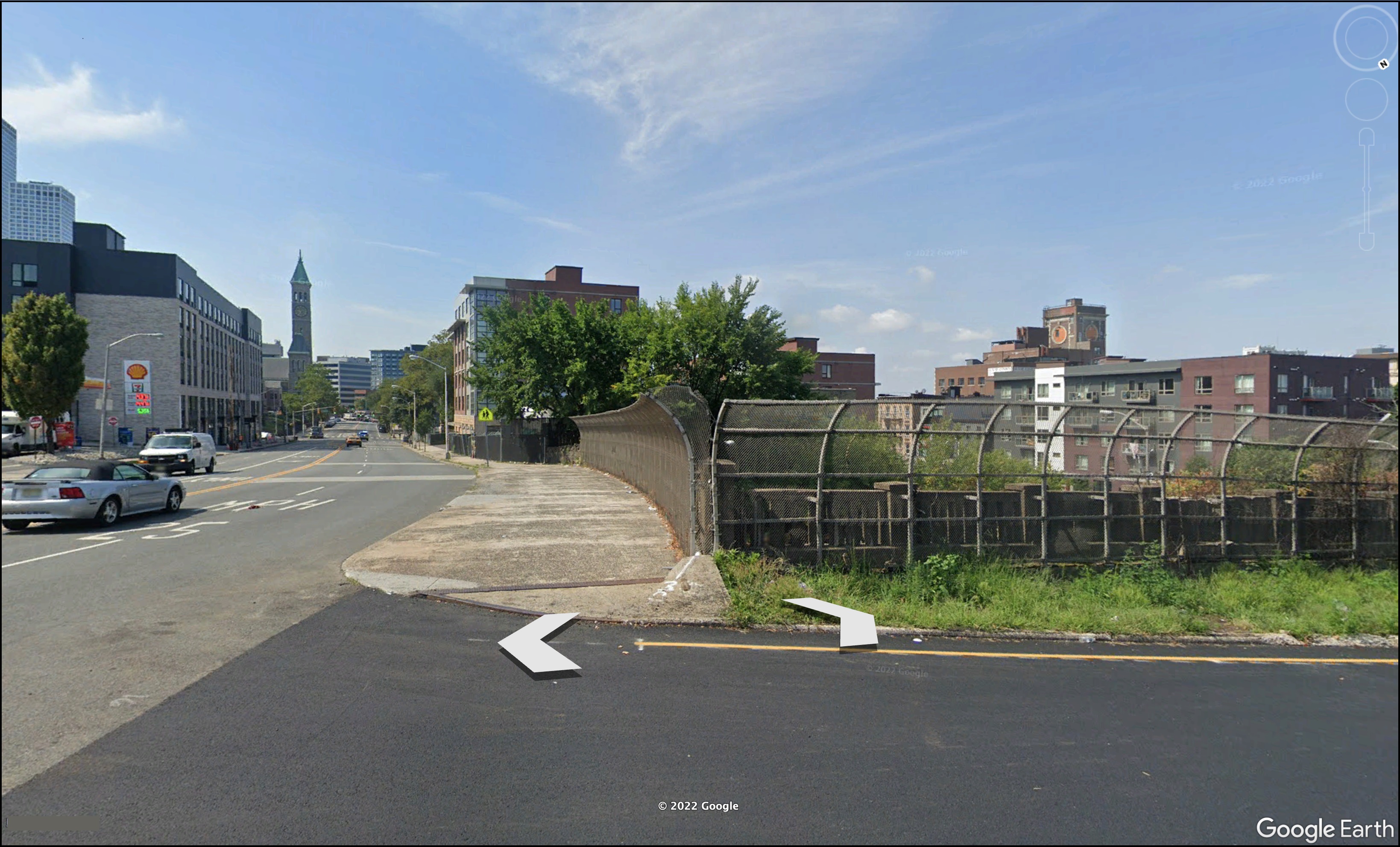 A.C. Chevrolet on Kennedy Boulevard in Jersey City is shielded by overgrowth on the right in this 2021 Google Earth image. In the distance, the tower of St. John the Baptist Roman Catholic Church rises.