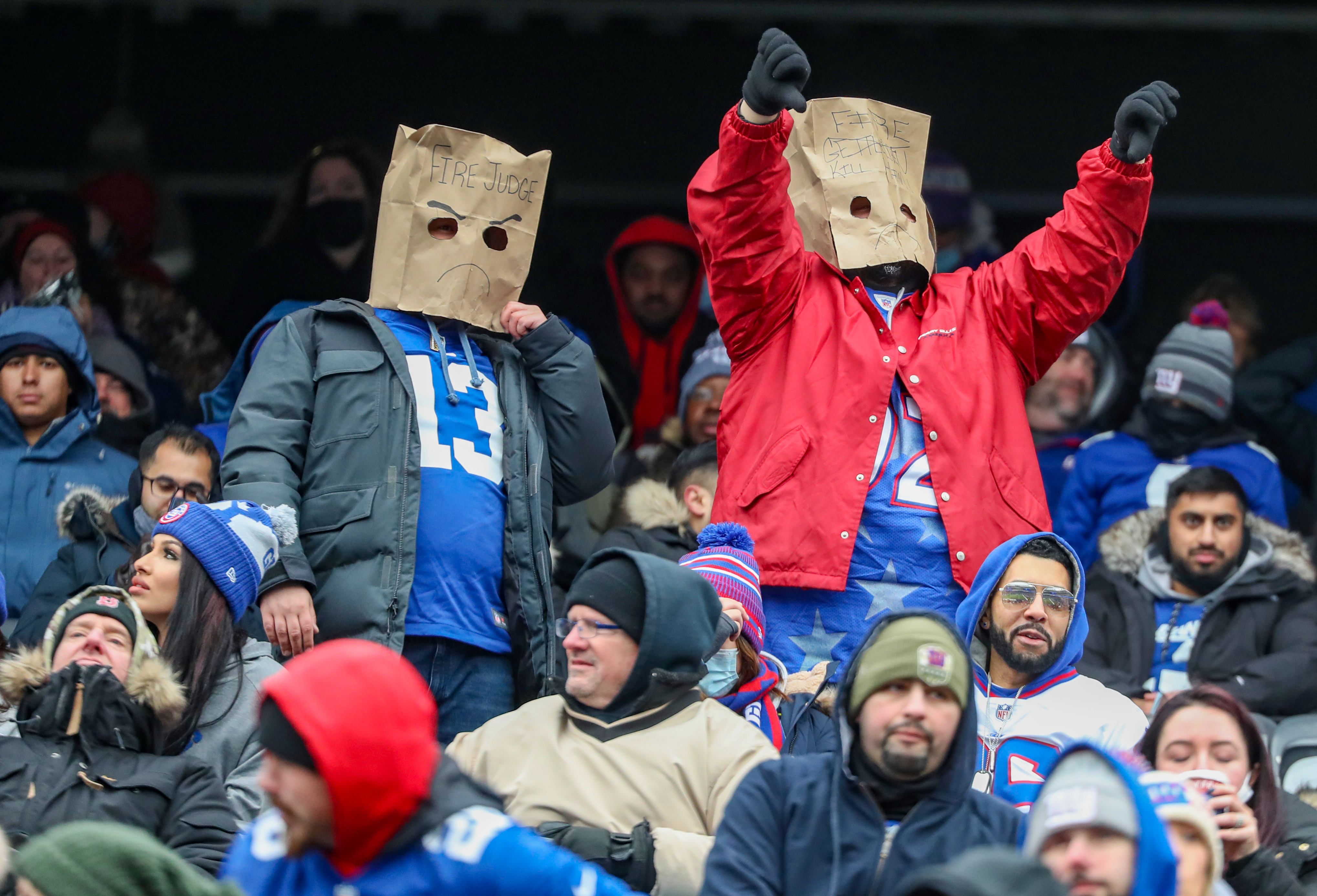 New York Mets fans, one wearing a paper bag over their head, watch