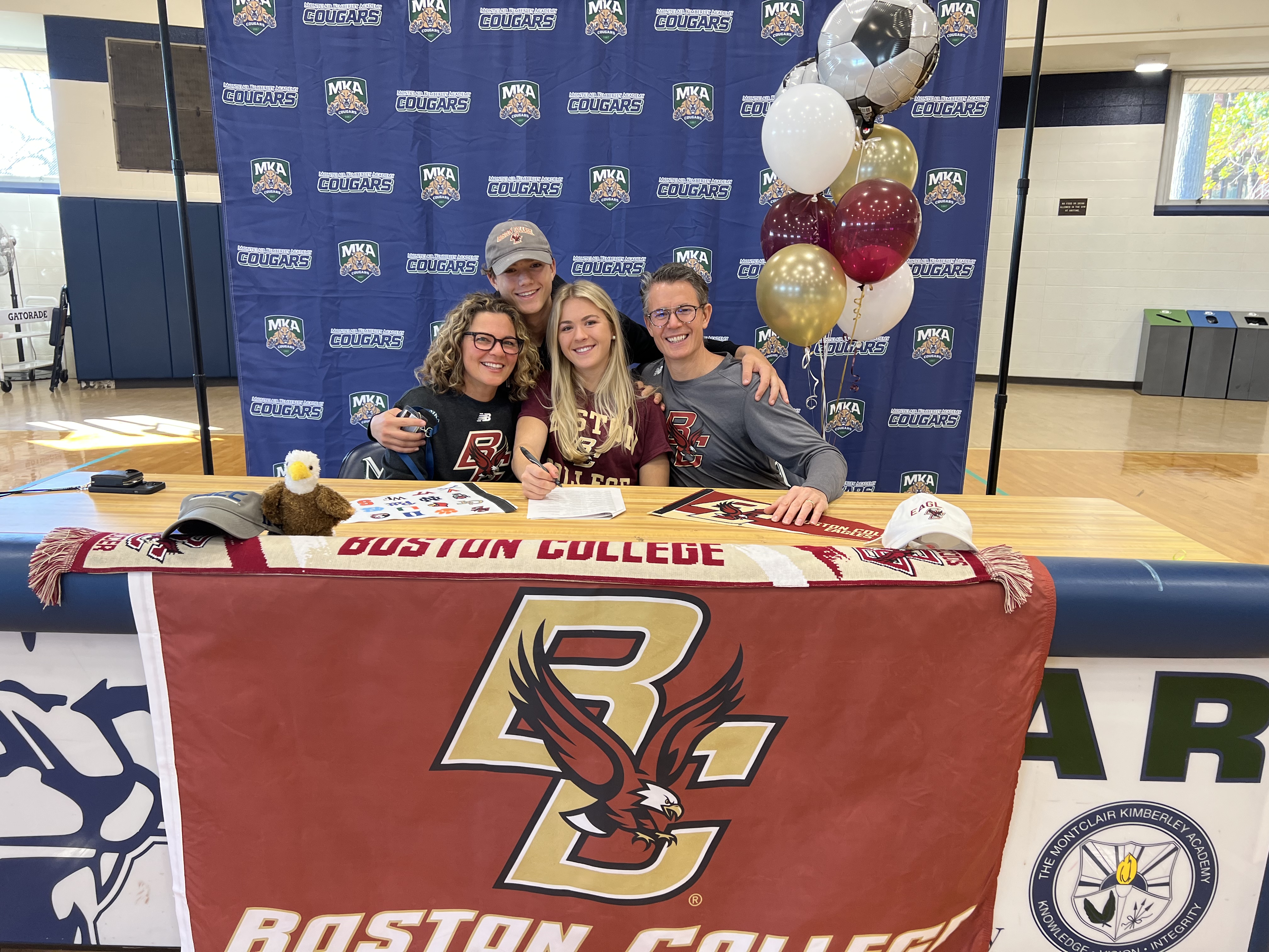 Bella Douglas of Montclair Kimberley signs to play soccer at Boston College. She is joined at the table with her mom, dad, and younger brother.