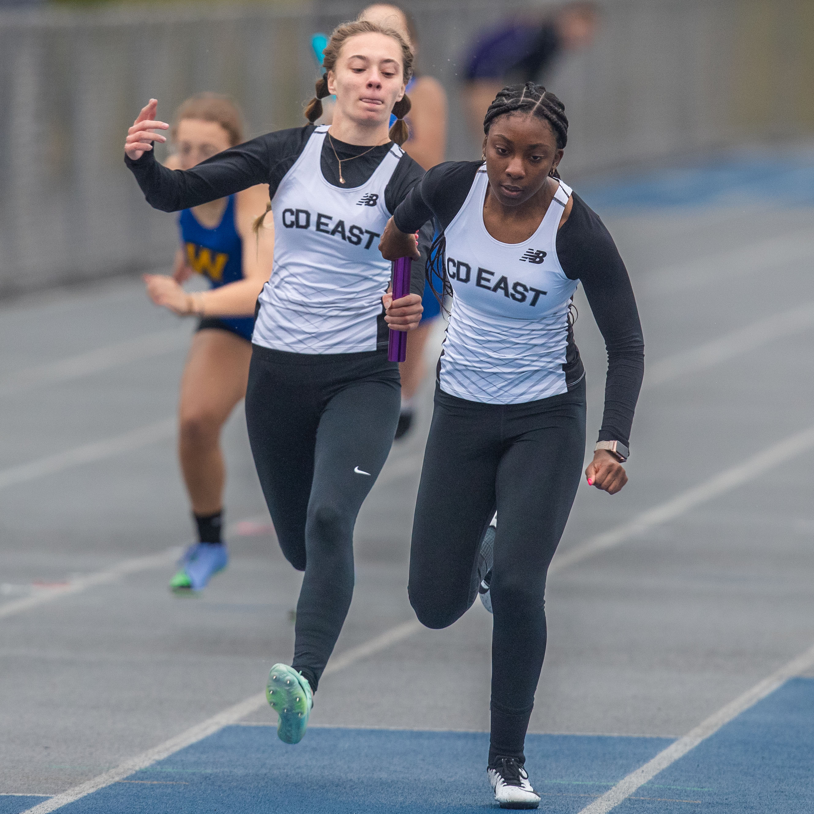 Central Dauphin East runners Livingston and Thomas exchange the baton as they win the 4 x 100 meter relay at the 2023 Tim Cook Memorial Invitational track & field meet at Chambersburg, Pa., Mar. 25, 2023.Mark Pynes | pennlive.com