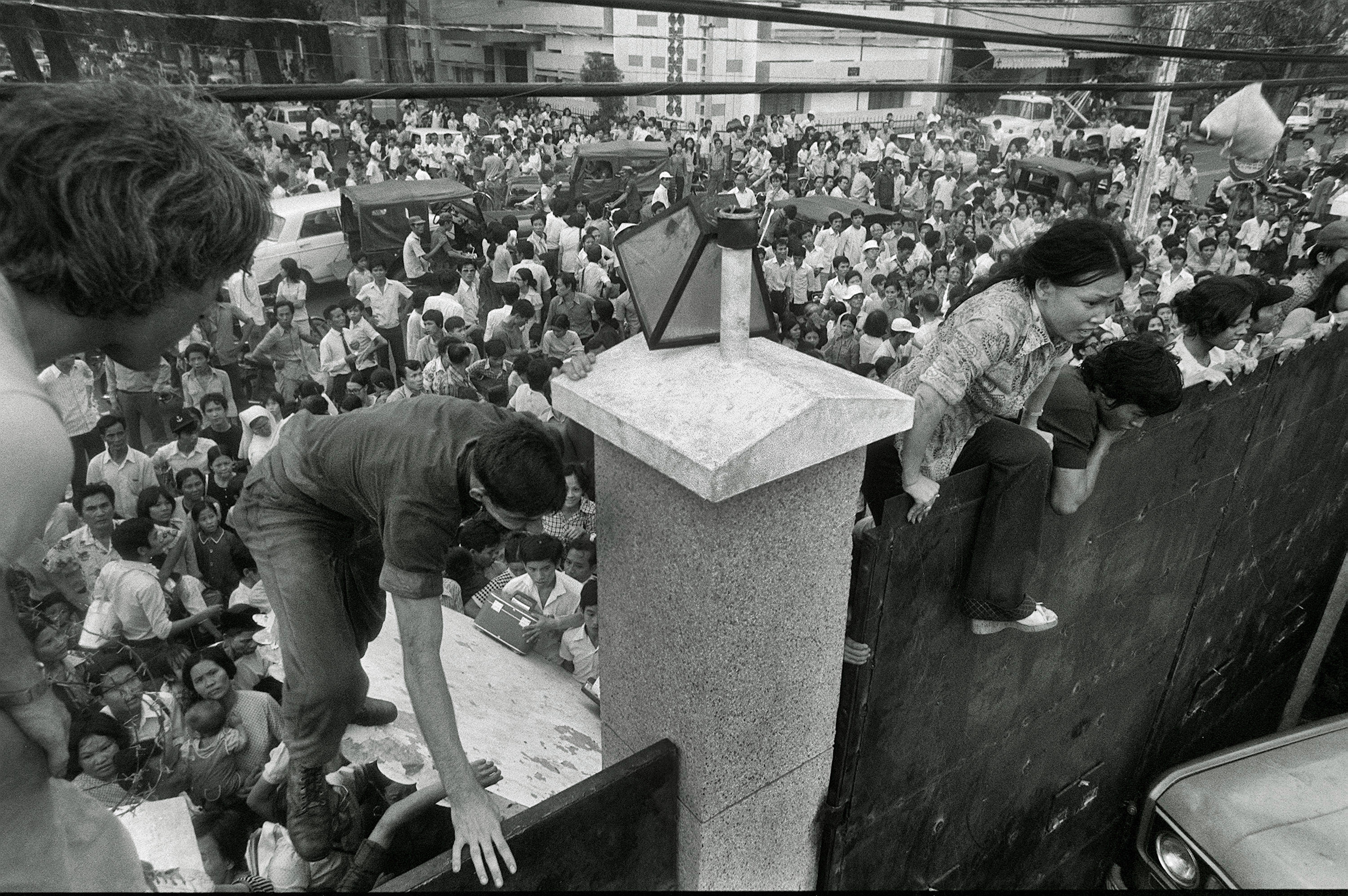 FILE - In this April 29, 1975 file photo, South Vietnamese civilians scale the 14-foot wall of the U.S. embassy in Saigon, trying to reach evacuation helicopters as the last Americans depart from Vietnam. (AP Photo/File)