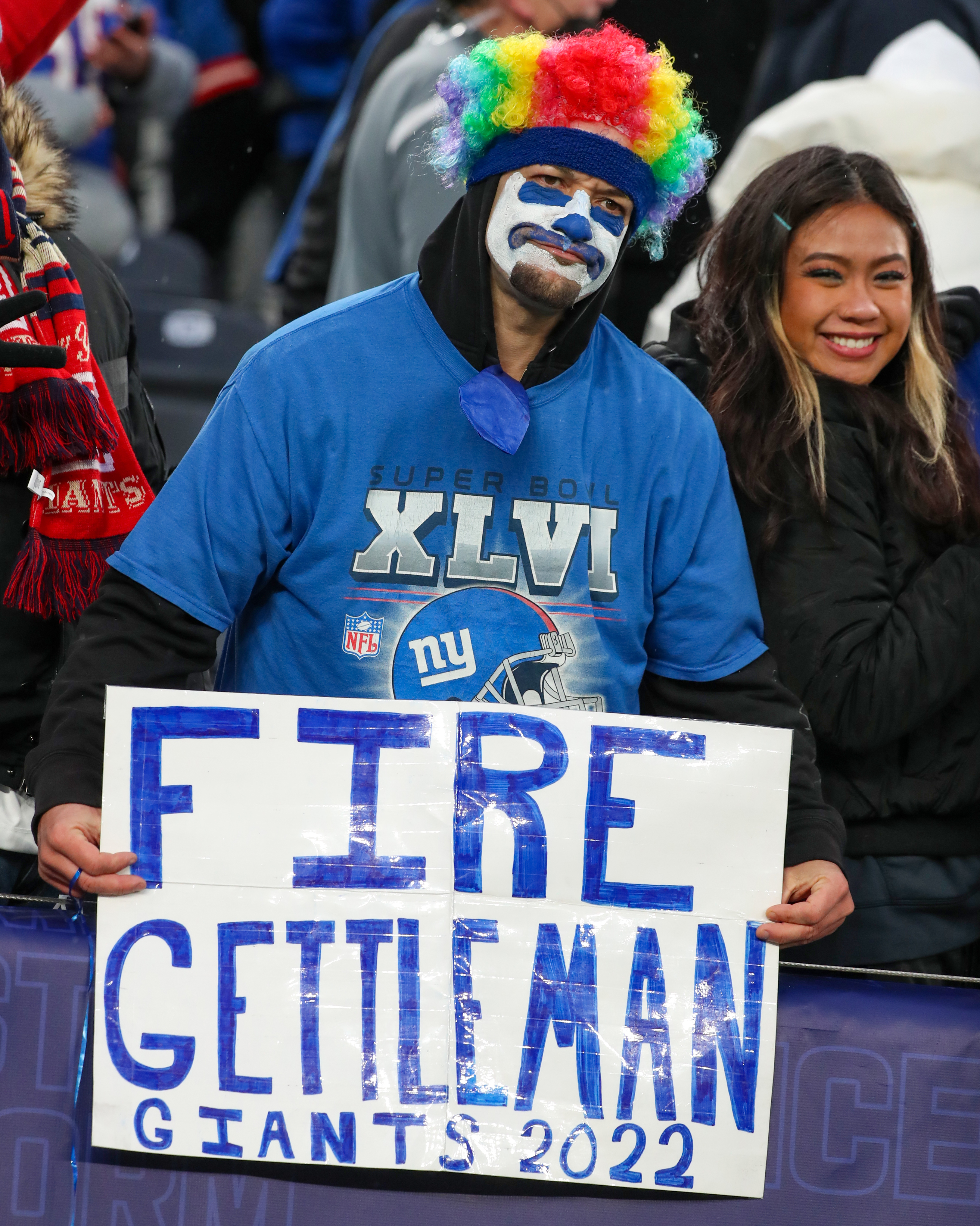 A fan dressed as a clown holds up a sign after the Giants lost 22-7 to Washington Football Team on Sunday, Jan. 9, 2022 in East Rutherford, N.J.