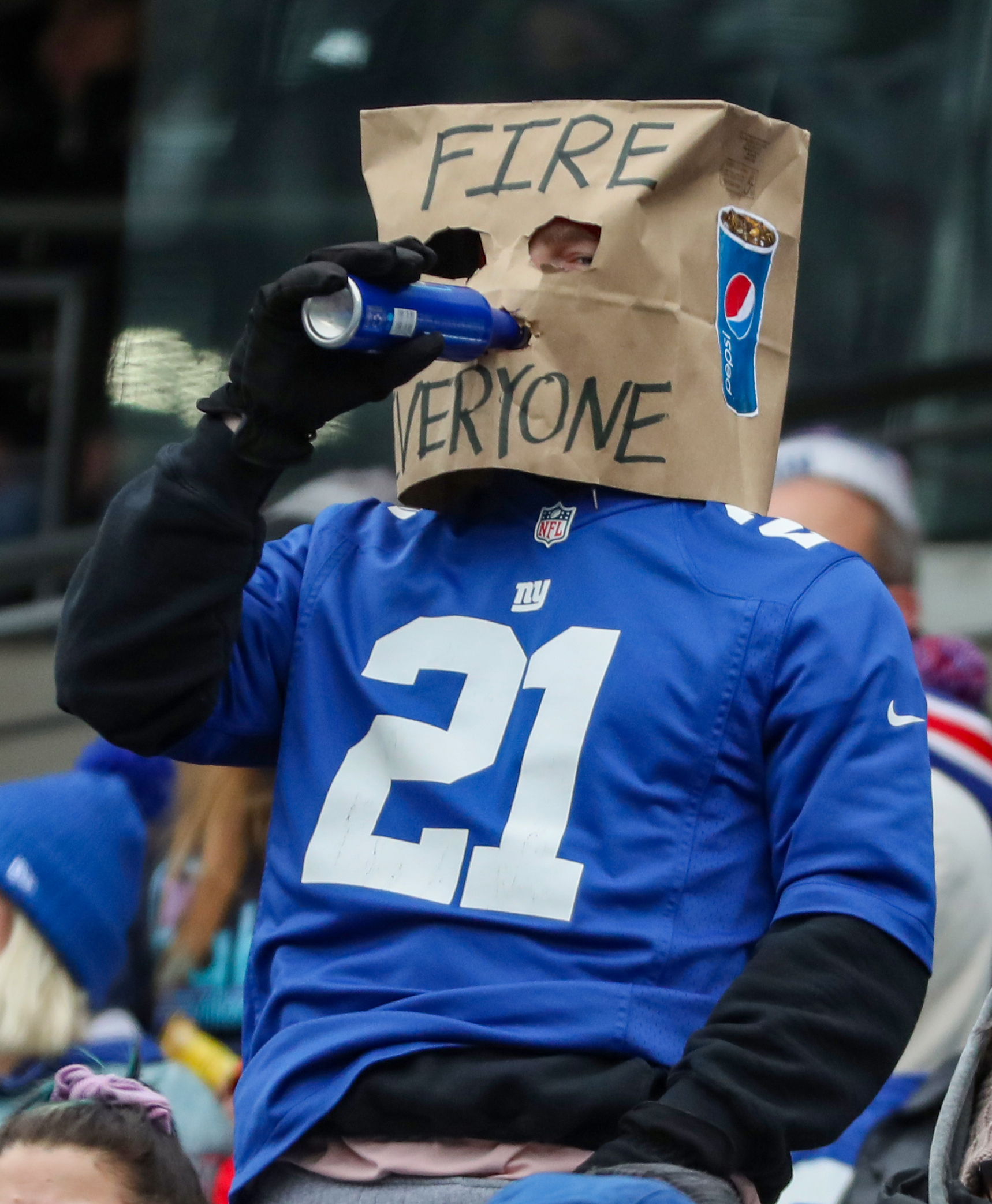 A fan drinks a beer wearing a bag on his head during the second quarter against the Washington Football Team on Sunday, Jan. 9, 2022 in East Rutherford, N.J.