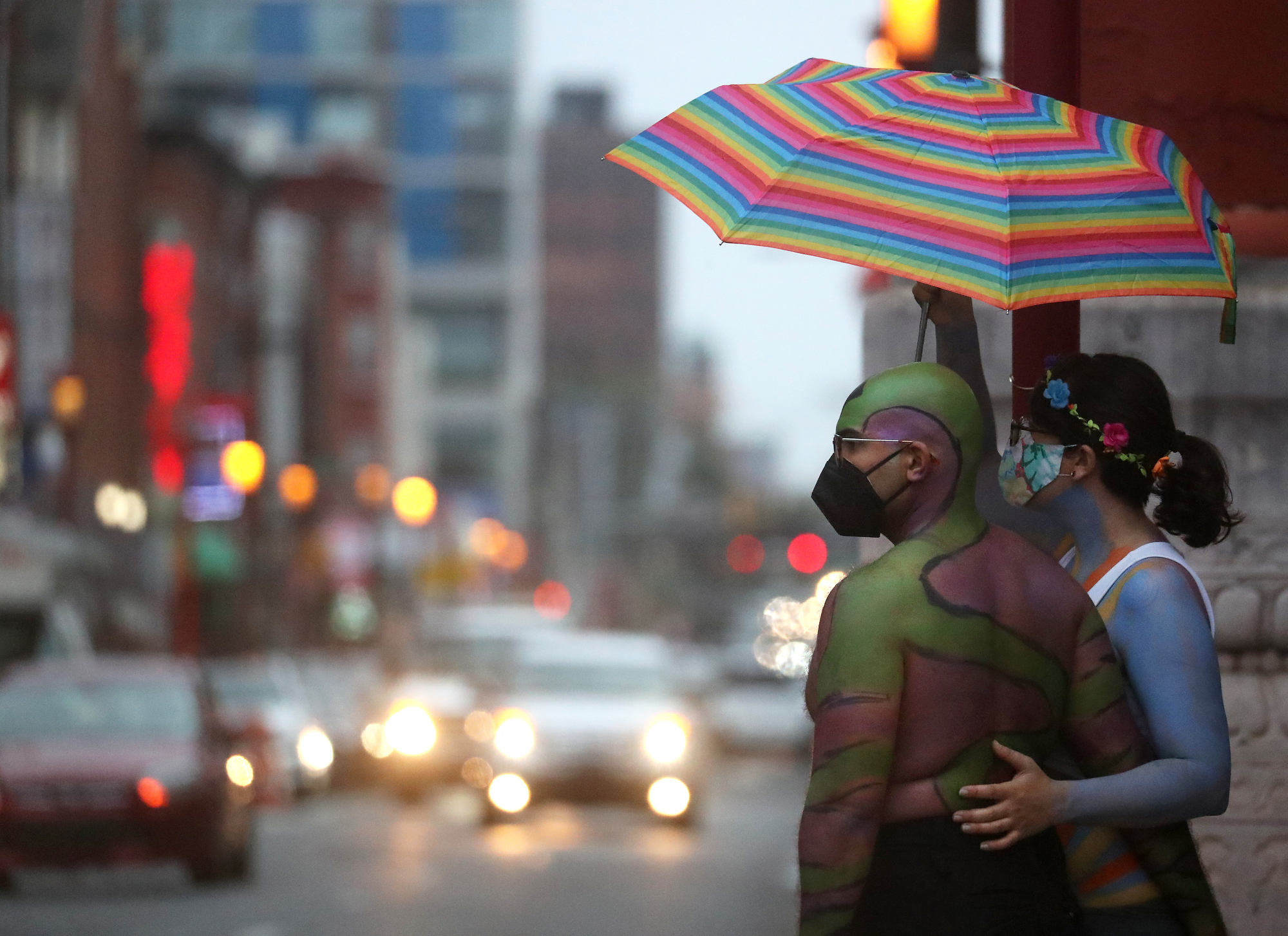 Two people wait the arrival of participants in the Philly Naked Bike Ride at the intersection of 10th and Arch streets in Philadelphia, Saturday, Aug. 28, 2021.