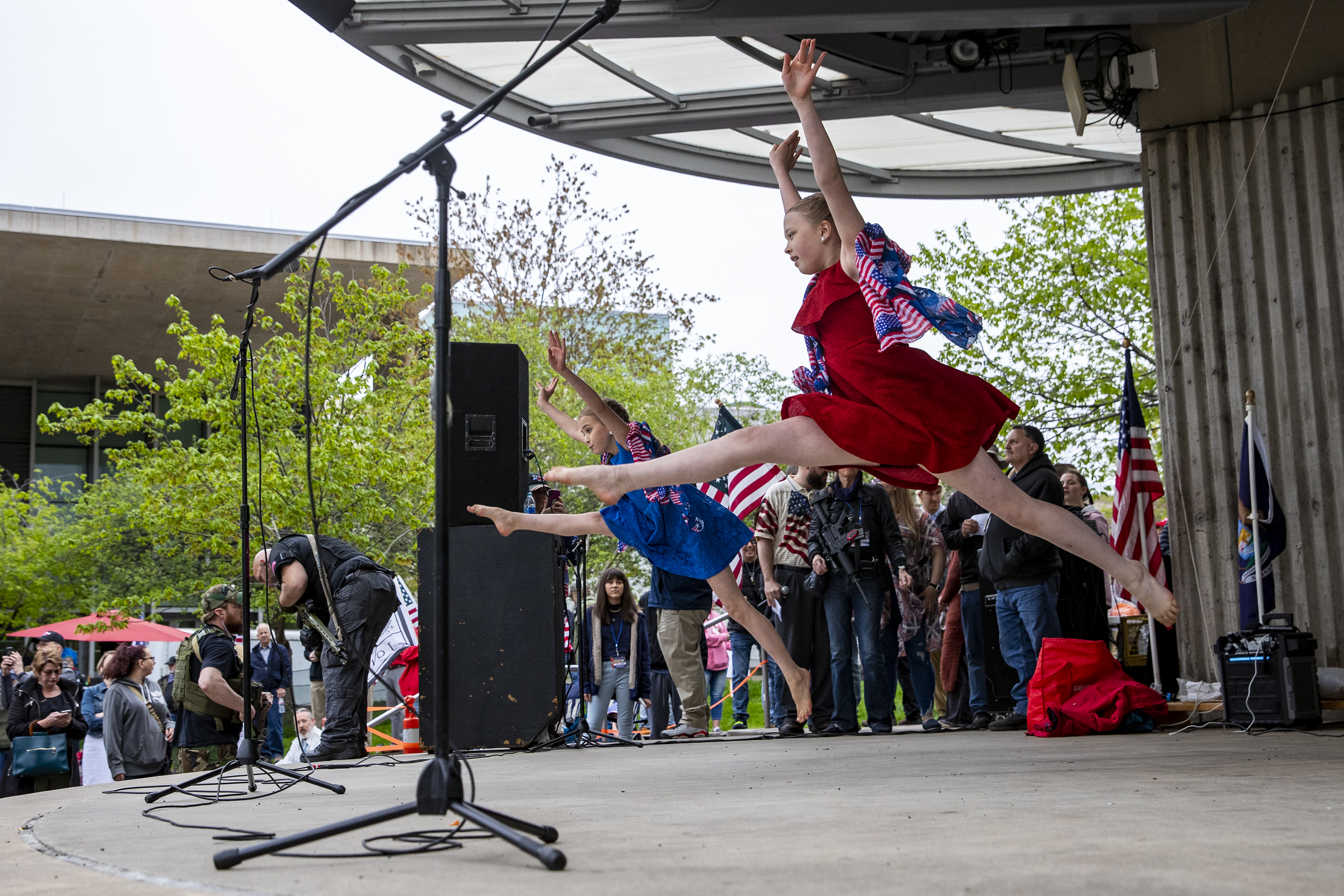Gracee, 10, left, and Hayden Heikkila, 13, perform a dance routine they developed to the song "We Bleed The Same Color" by Mandisa, featuring TobyMac and Kirk Franklin, during the "American Patriot Rally-Sheriffs speak out" event at Rosa Parks Circle in downtown Grand Rapids on Monday, May 18, 2020. The crowd is protesting against Gov. Gretchen Whitmer's stay-at-home order. The sisters are from Battle Creek. (Cory Morse | MLive.com)