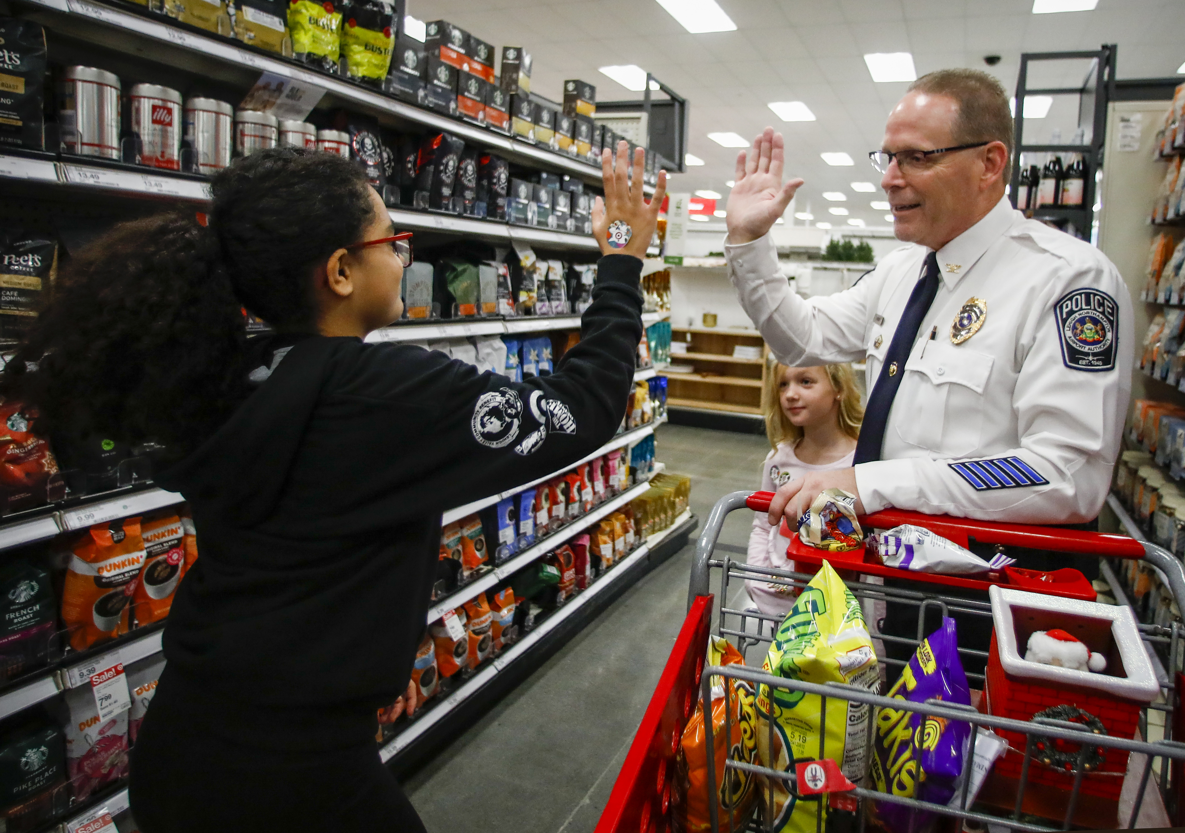  Chief Timothy Koder, right,  gives Aniya Bermudez, 12, a high-five after selecting a gift for her dad during a holiday shopping spree Saturday, Dec. 3, 2022, at Target in Hanover Township, Lehigh County. 