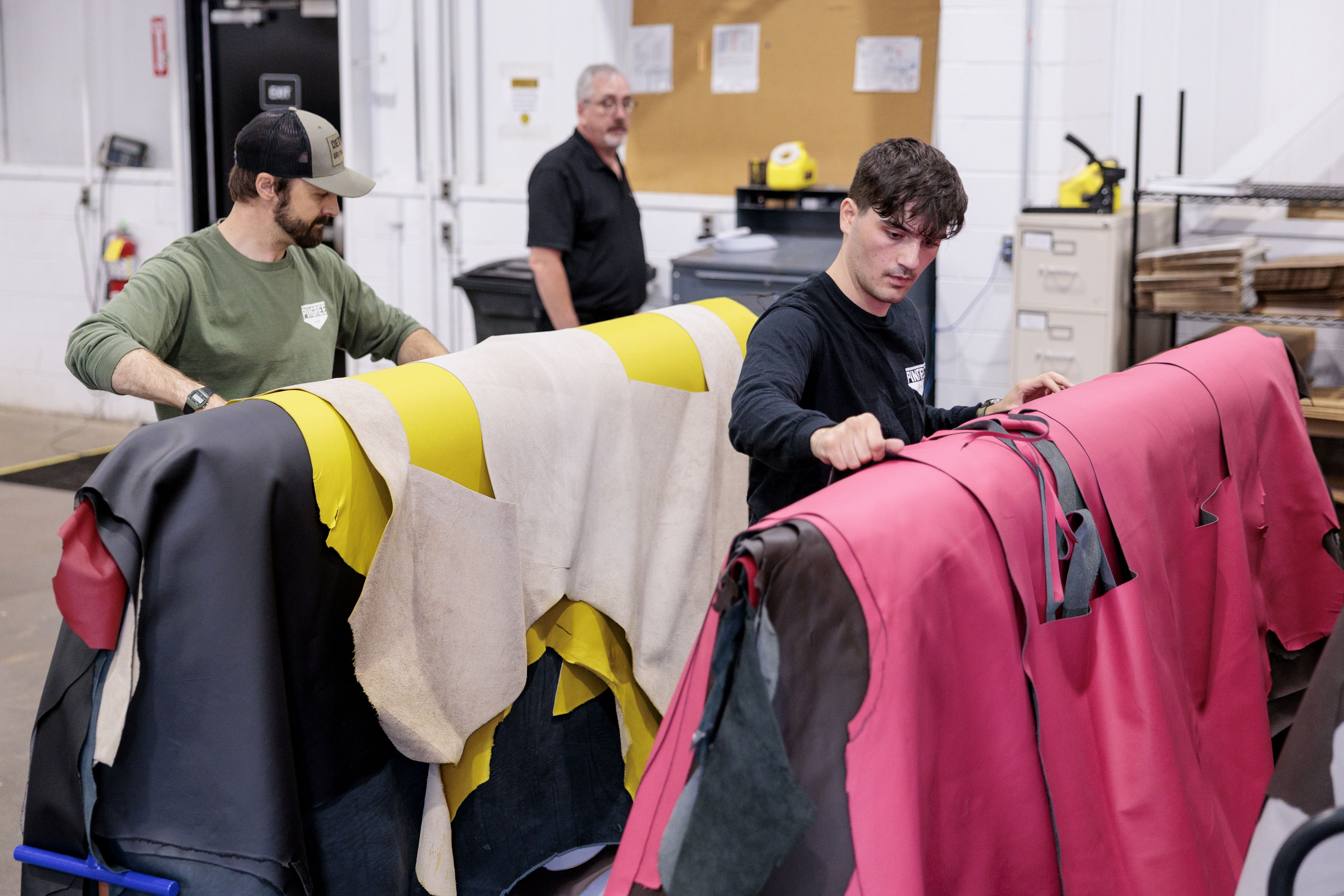 From left, Pingree Detroit’s Jarrett Schlaff and Eric Rranxburgaj sort through automotive leather donated by Pangea at the automotive supplier’s offices in Rochester Hills on Monday, Oct. 6 2025.