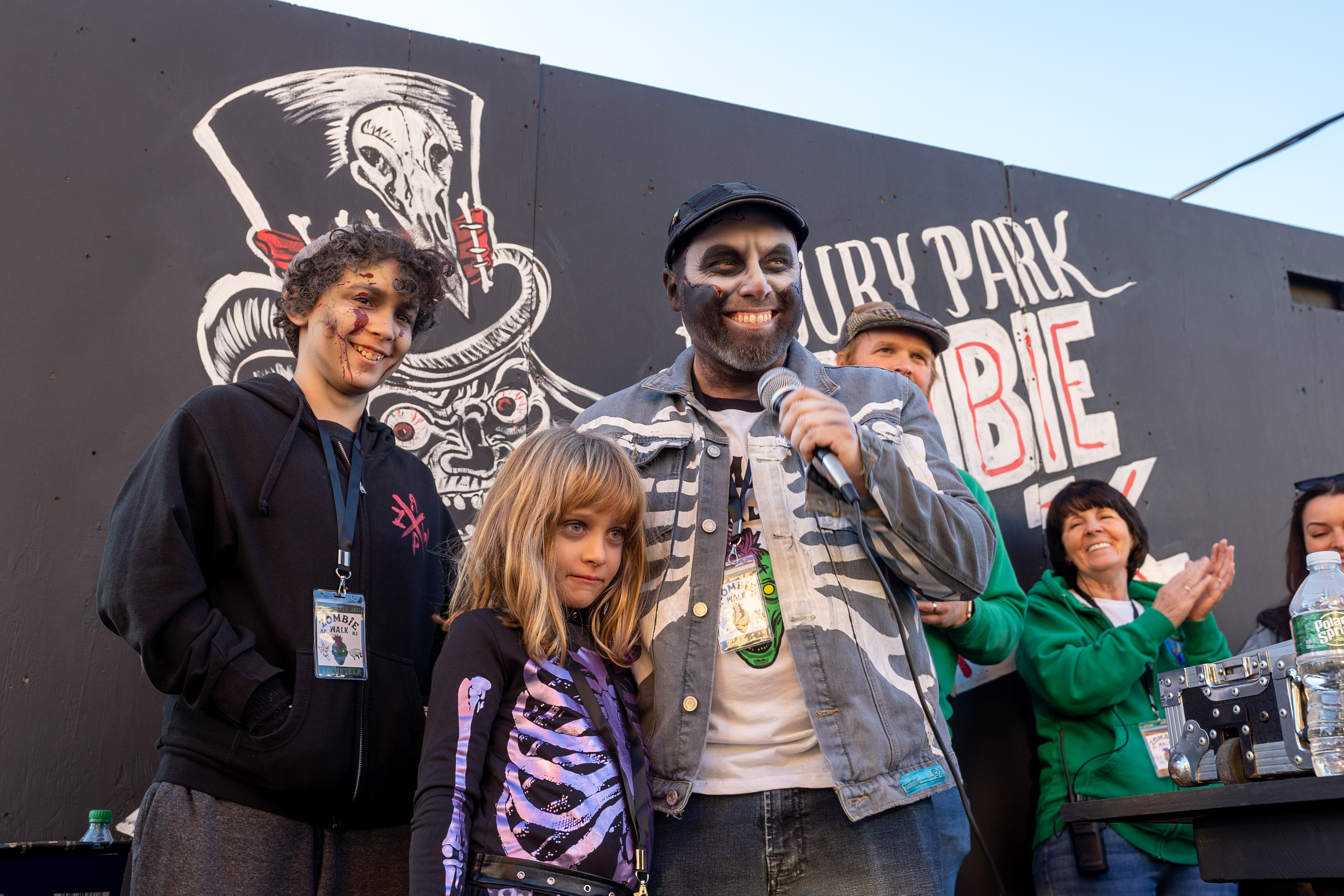 Jason Meehan, the founder of Asbury Park Zombie walk, stands on stage with his family during the 14th Asbury Park Zombie Walk in Asbury Park on Saturday, October 8, 2022. The zombie walk held its first themed year with the theme being 80's and 90's punk and metal.
