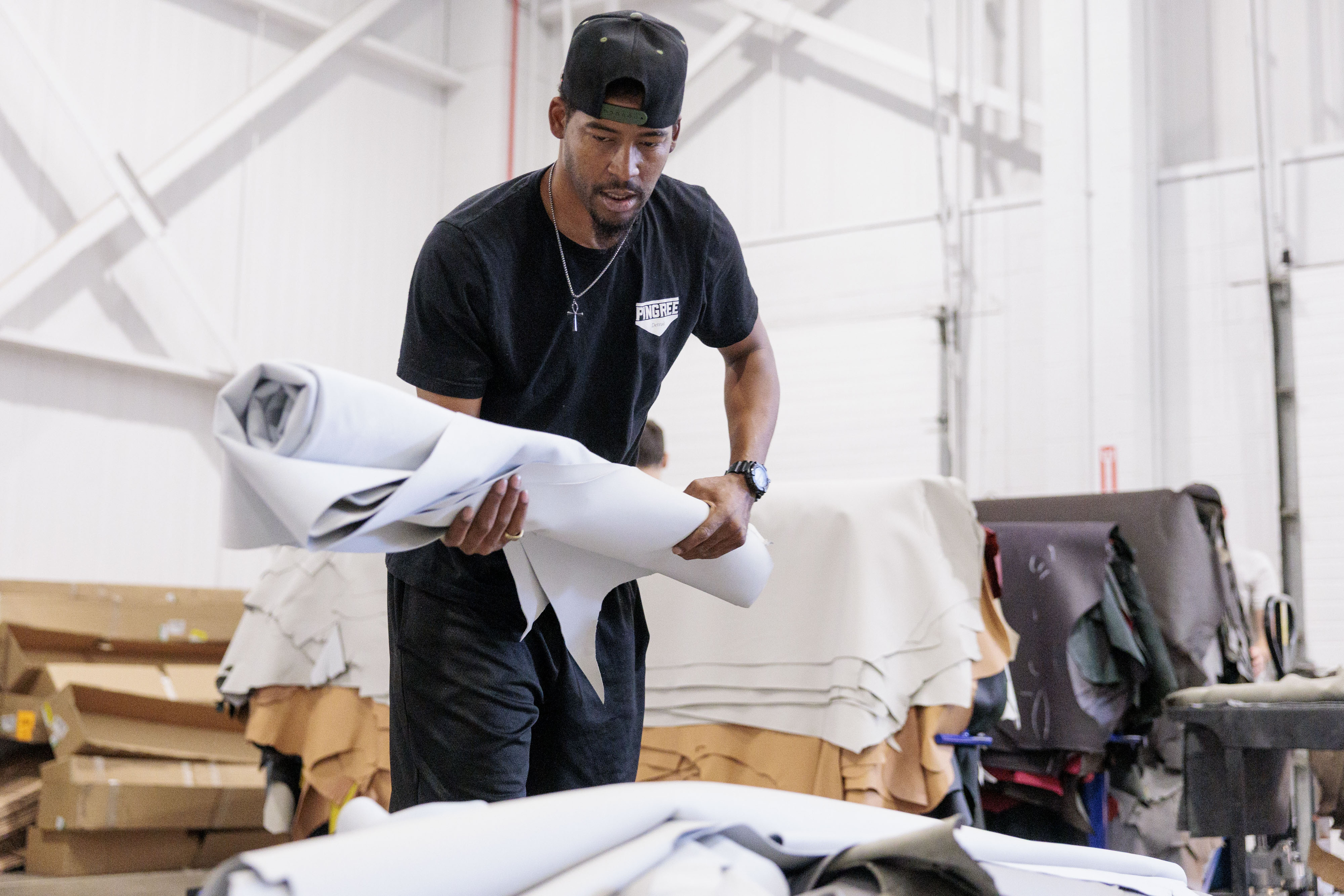 Nathaniel Crawford II, Co-Owner and Vice President of Footwear Operations at Pingree Detroit, sorts through donated automotive leather at Pangea in Rochester Hills on Monday, Oct. 6 2025.