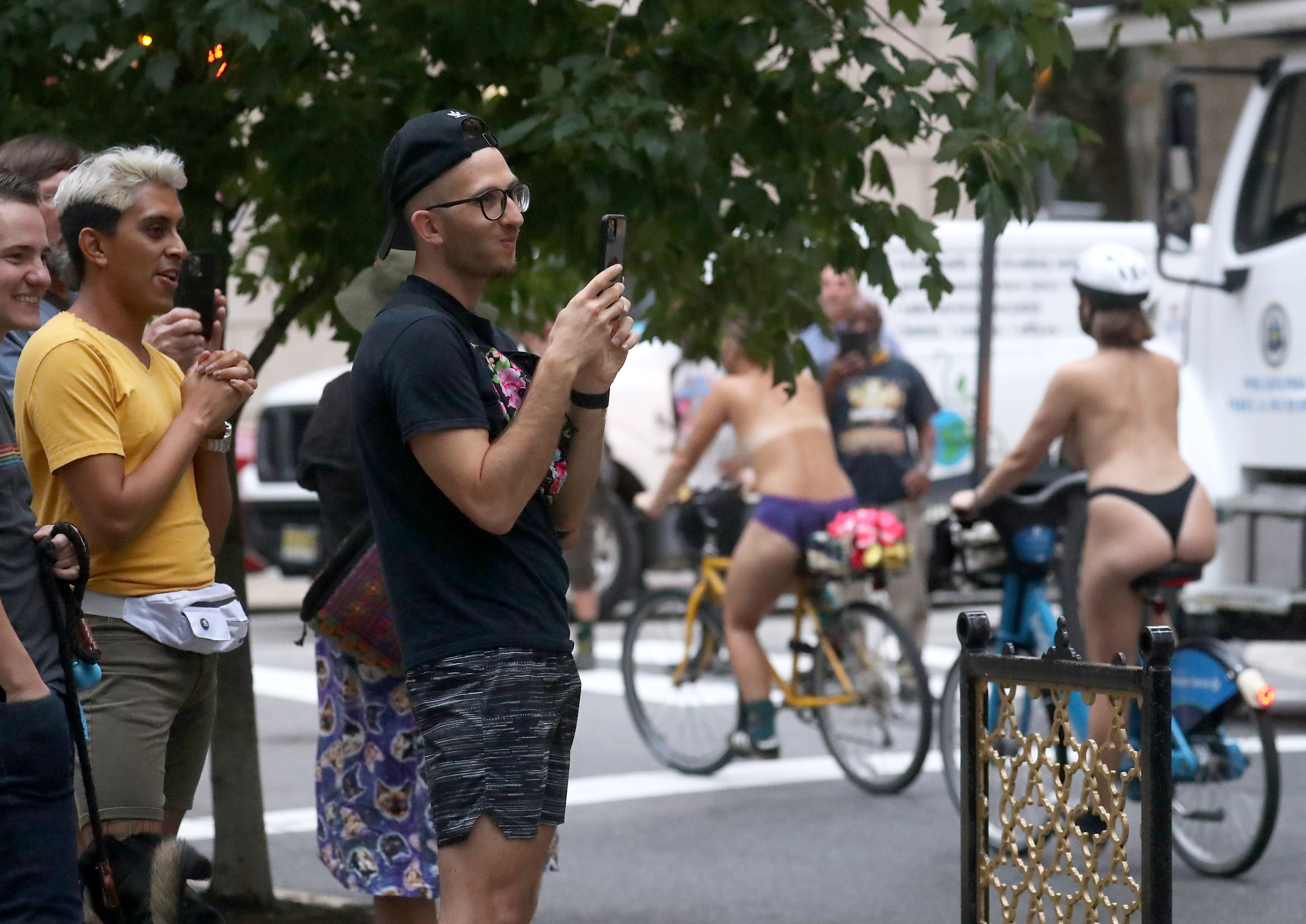 People watch and record participants in the the Philly Naked Bike Ride at Rittenhouse Square in Philadelphia Saturday, Aug. 28, 2021.