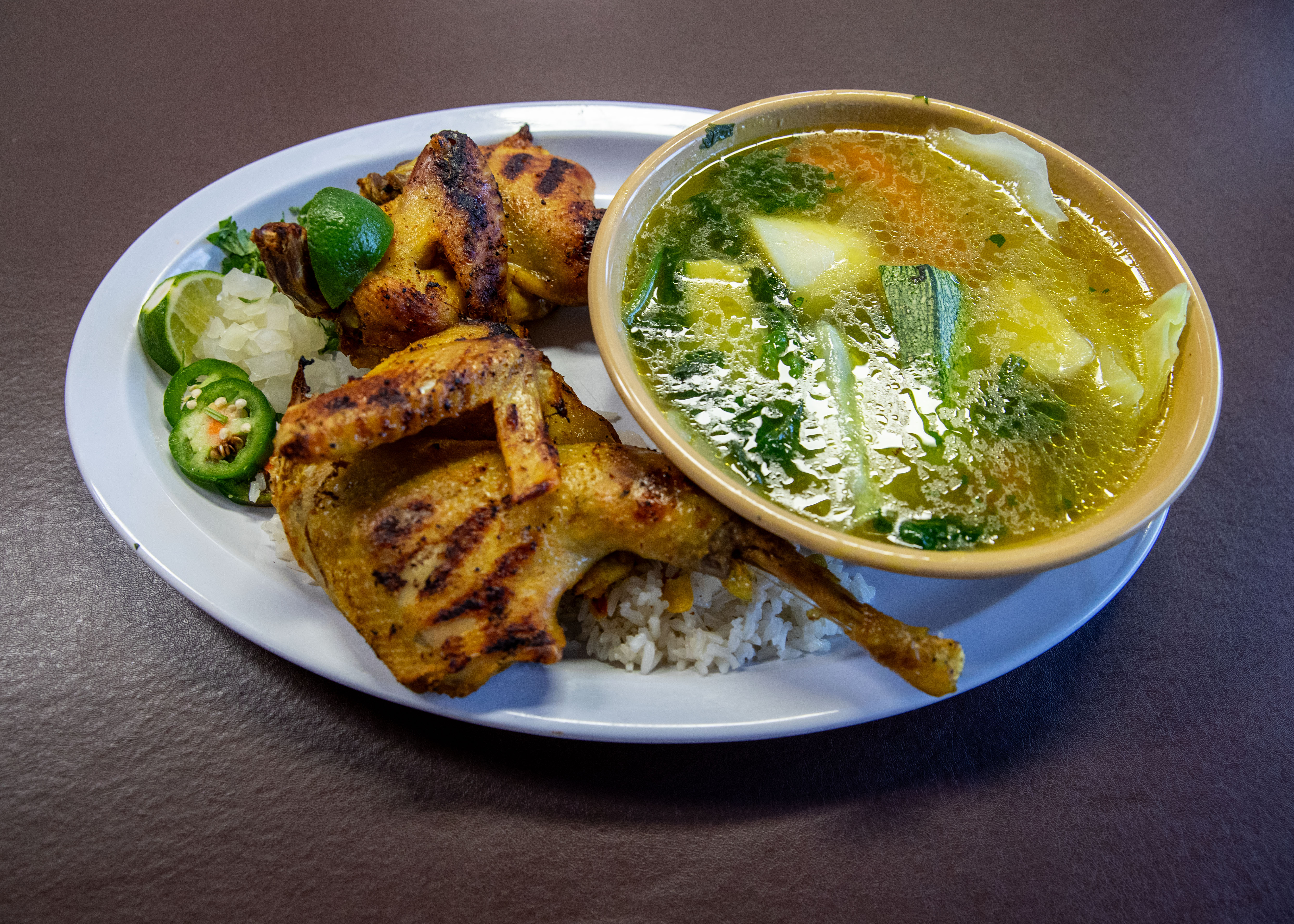 Sopa con Gallino Asada (chicken soup) with roasted Indian hen, rice, onion, lime and jalapeño for $19.99 at Pupuseria El Salvador in Wyoming on Thursday, Oct. 19, 2023. (Cory Morse | MLive.com)

