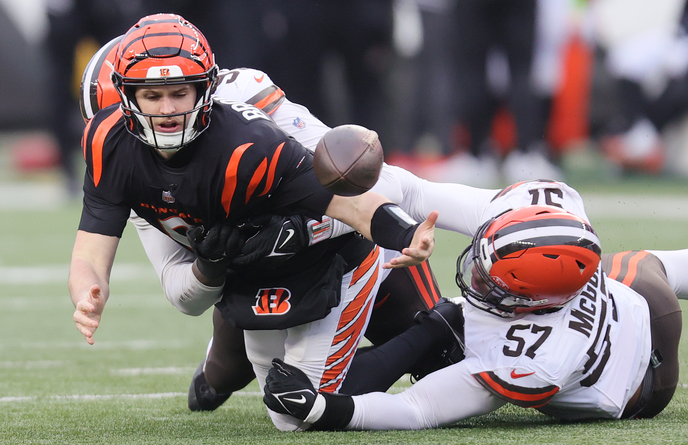 Cleveland Browns defensive end Alex Wright (behind) and Cleveland Browns defensive end Isaiah McGuire team up to sack Cincinnati Bengals quarterback Jake Browning as he momentarily loses possession of the football on a pass play