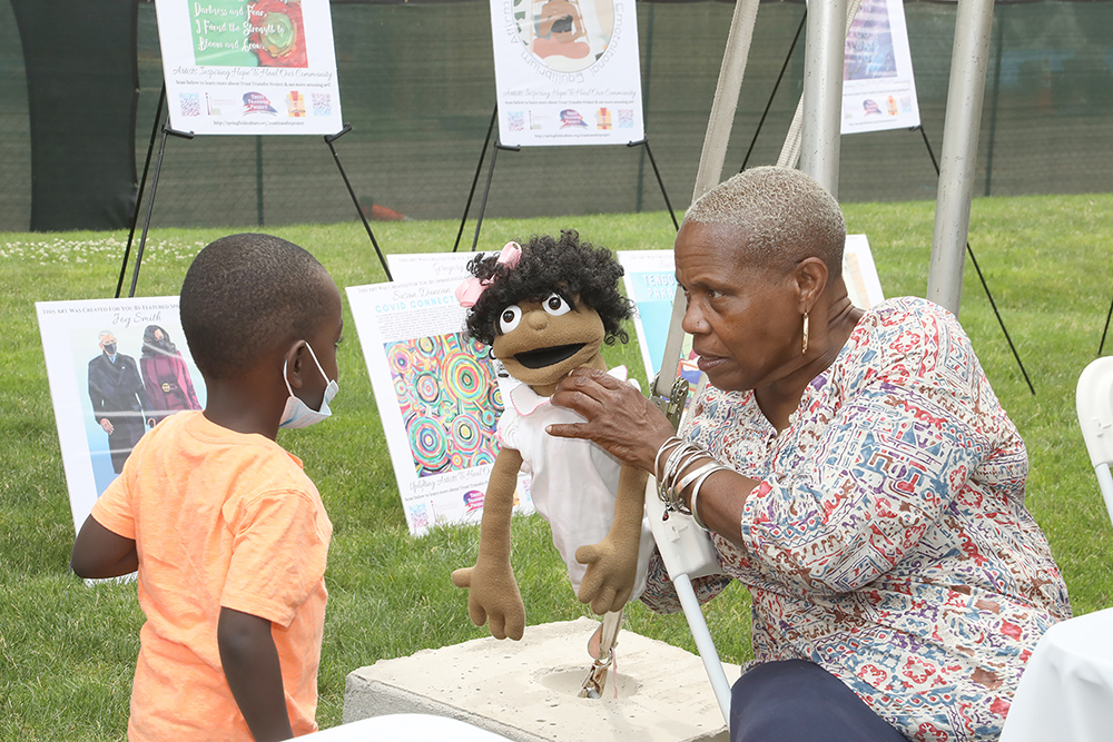 Darlene Savage shows off one of her hand puppets at Chalk for Change 2022 taking place at Court Square in Springfield on July 16th. (Ed Cohen Photo)