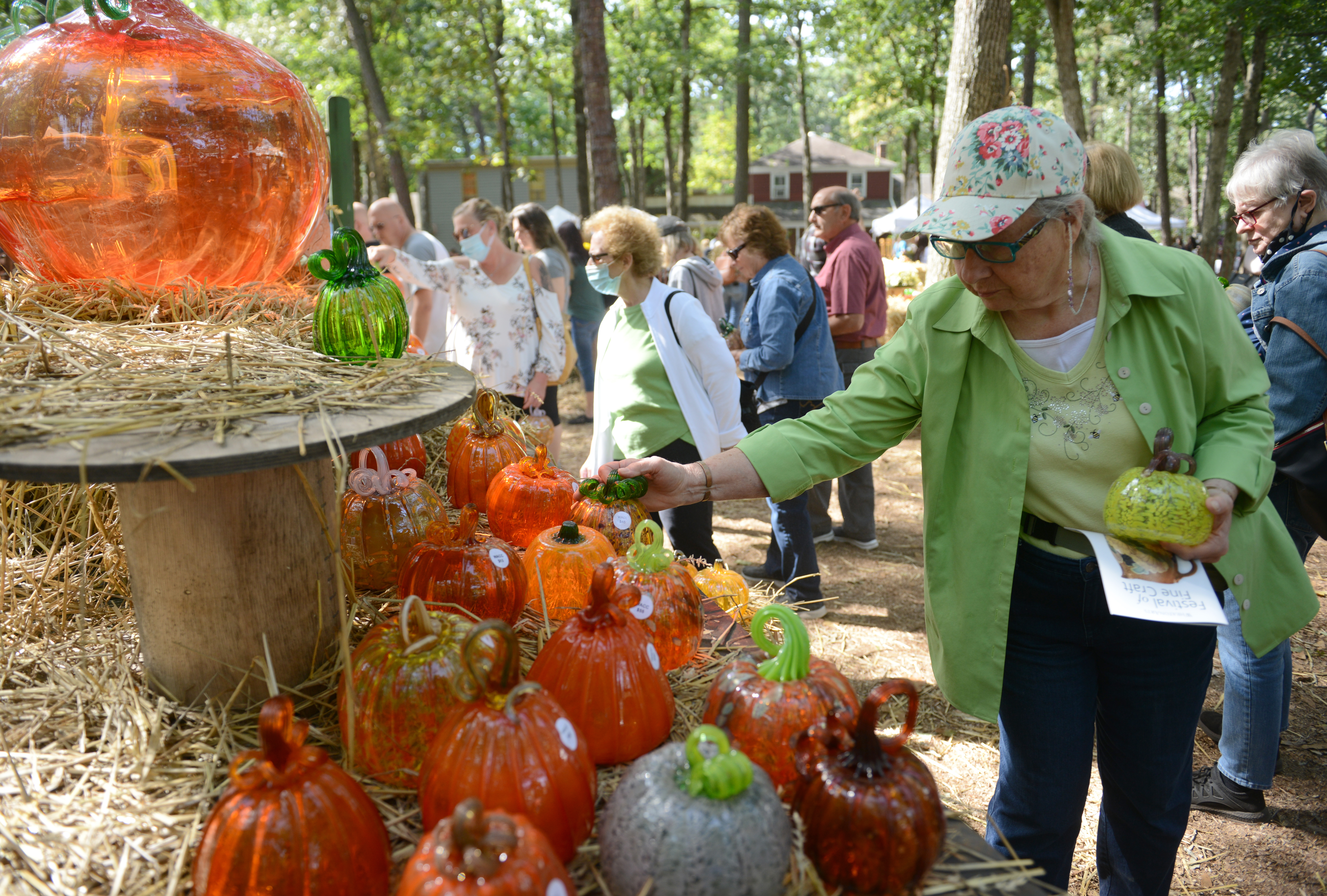 Customers browse the glass pumpkin patch during the 22nd annual Festival of Fine Craft at Wheaton Arts in Millville, Saturday, Oct. 2, 2021.