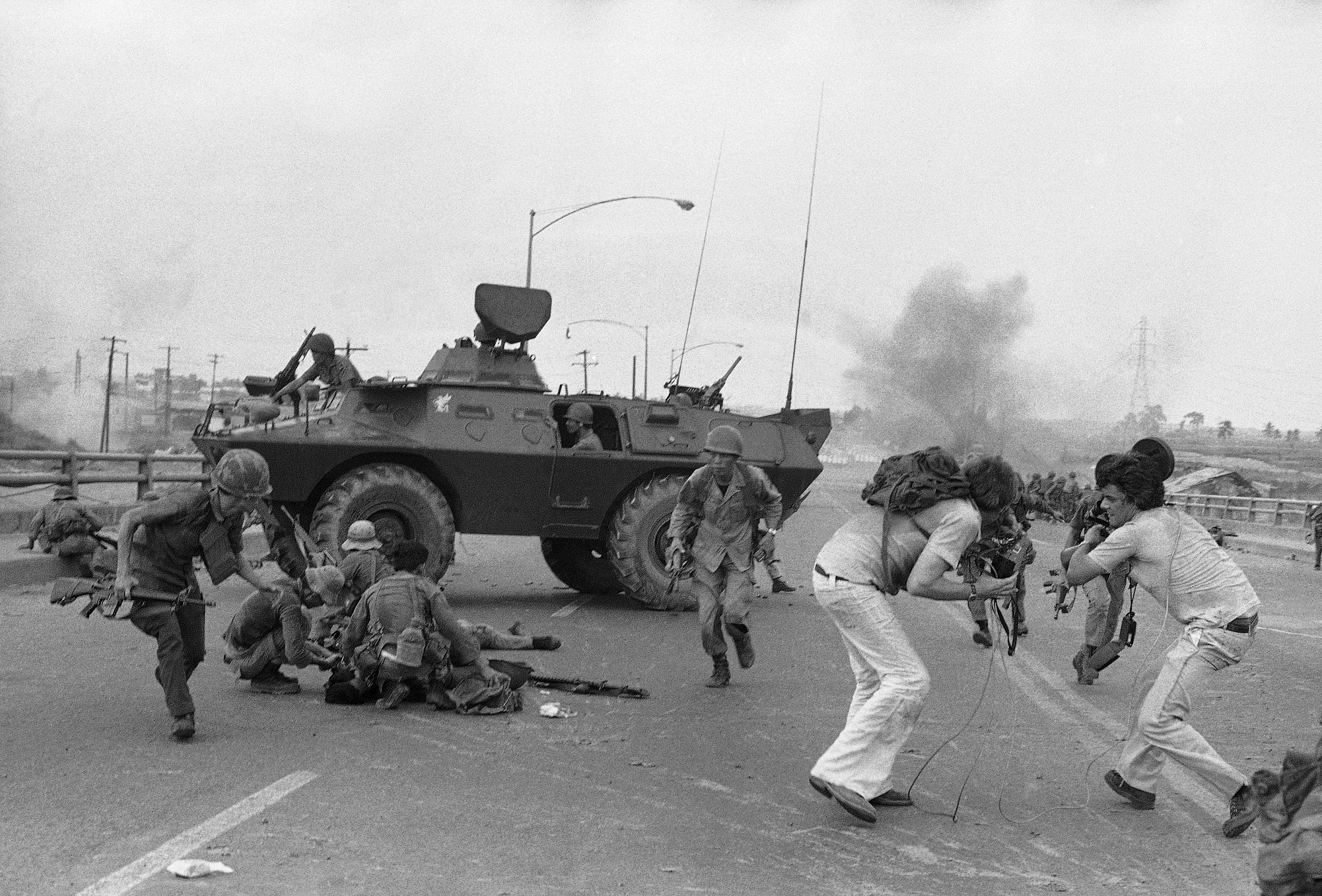 FILE - In this Monday, April 28, 1975 file photo, South Vietnamese troops and western TV newsmen run for cover as a North Vietnamese mortar round explodes on Newport Bridge on the outskirts of Saigon. (AP Photo/Hoanh, File)