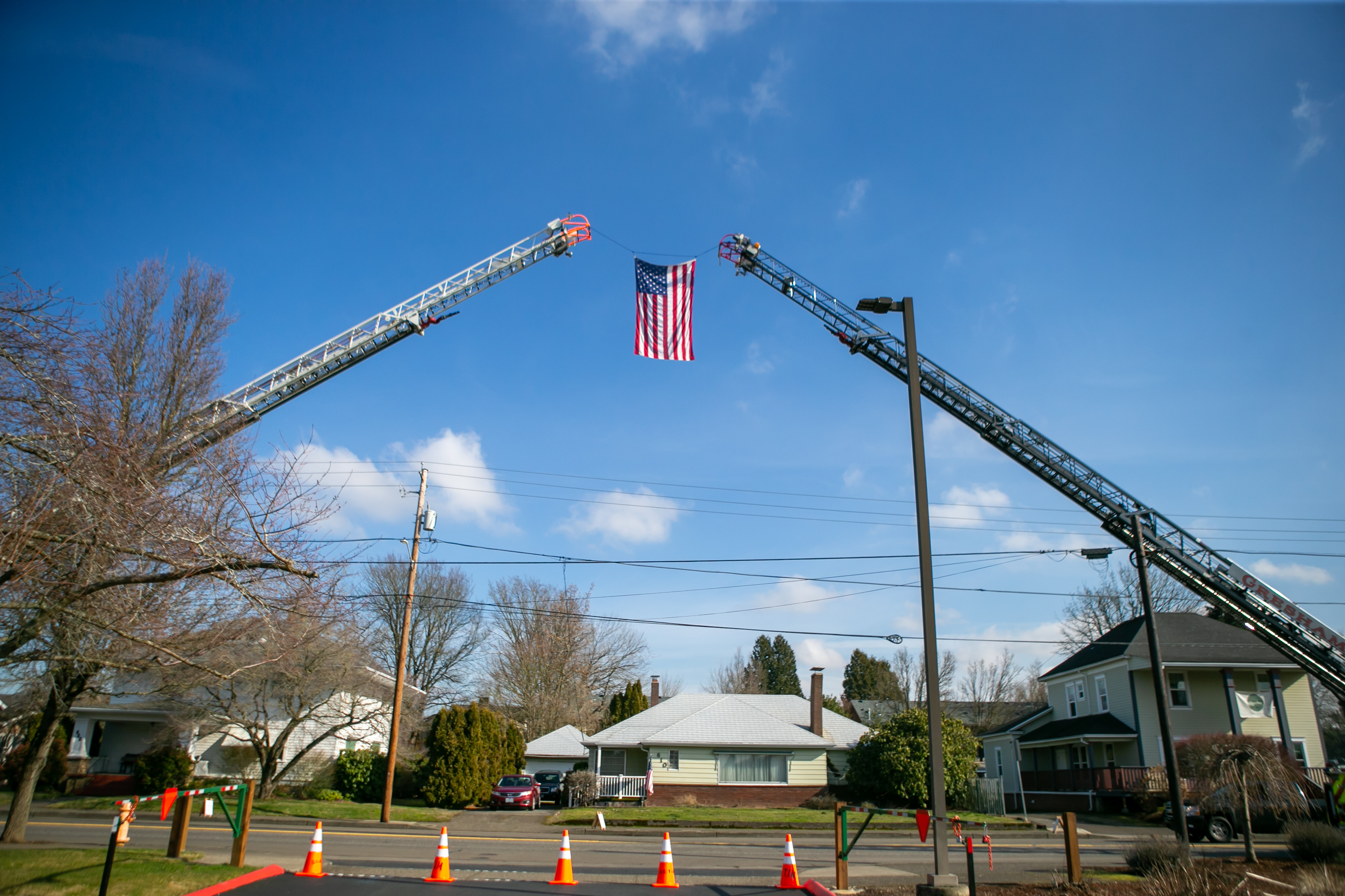 An American flag files outside of a memorial service honoring Gresham Firefighter Brandon Norbury in downtown Gresham, Oregon on Wednesday, Feb. 15 2023.