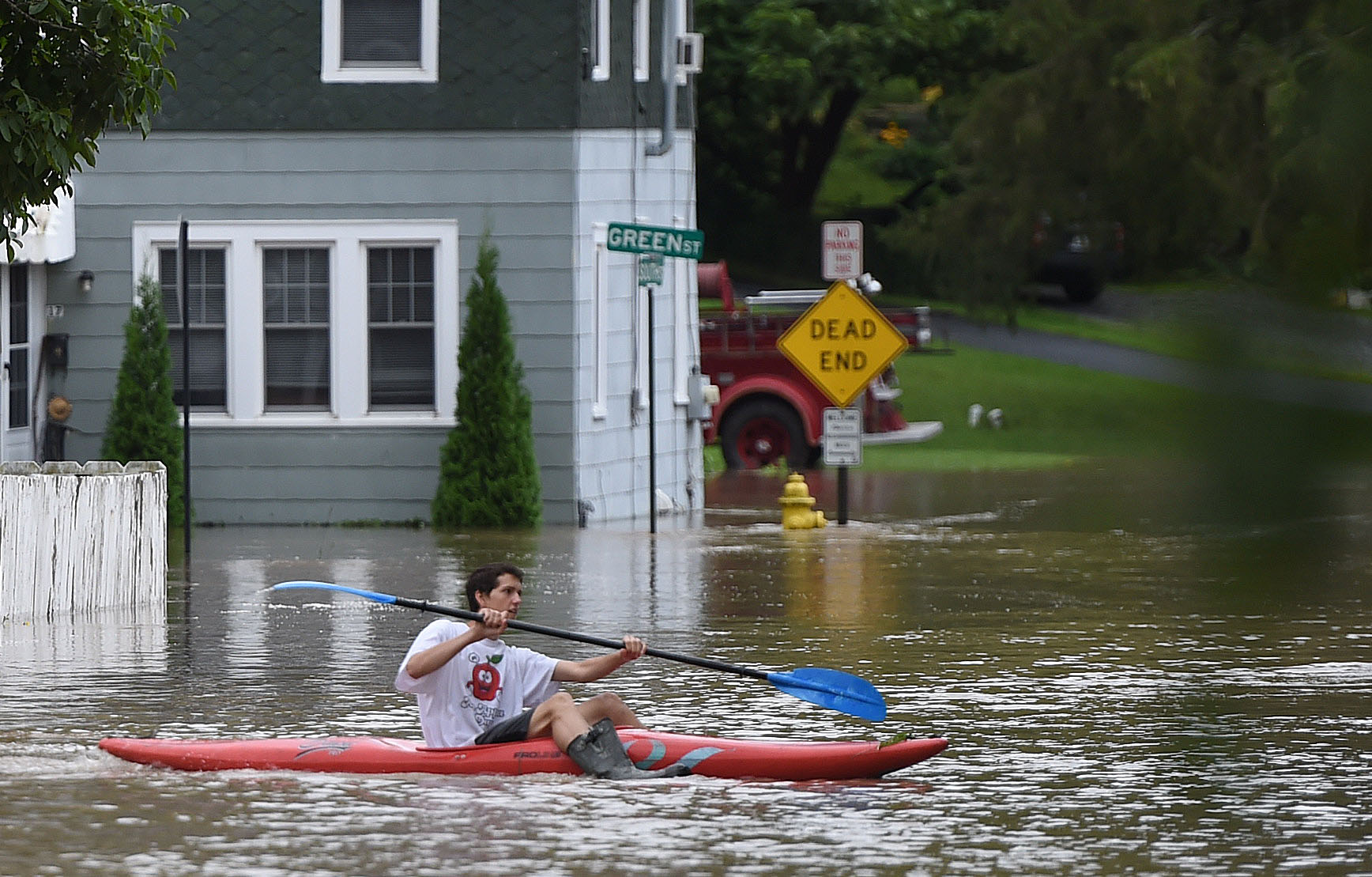 A young man takes his kayak out on Green and South streets August 19, 2021. Heavy rains again created flooding in Central New York. A lot of the flooding occurred along Ninemile Creek in Camillus and Marcellus. Dennis Nett | dnett@syracuse.com