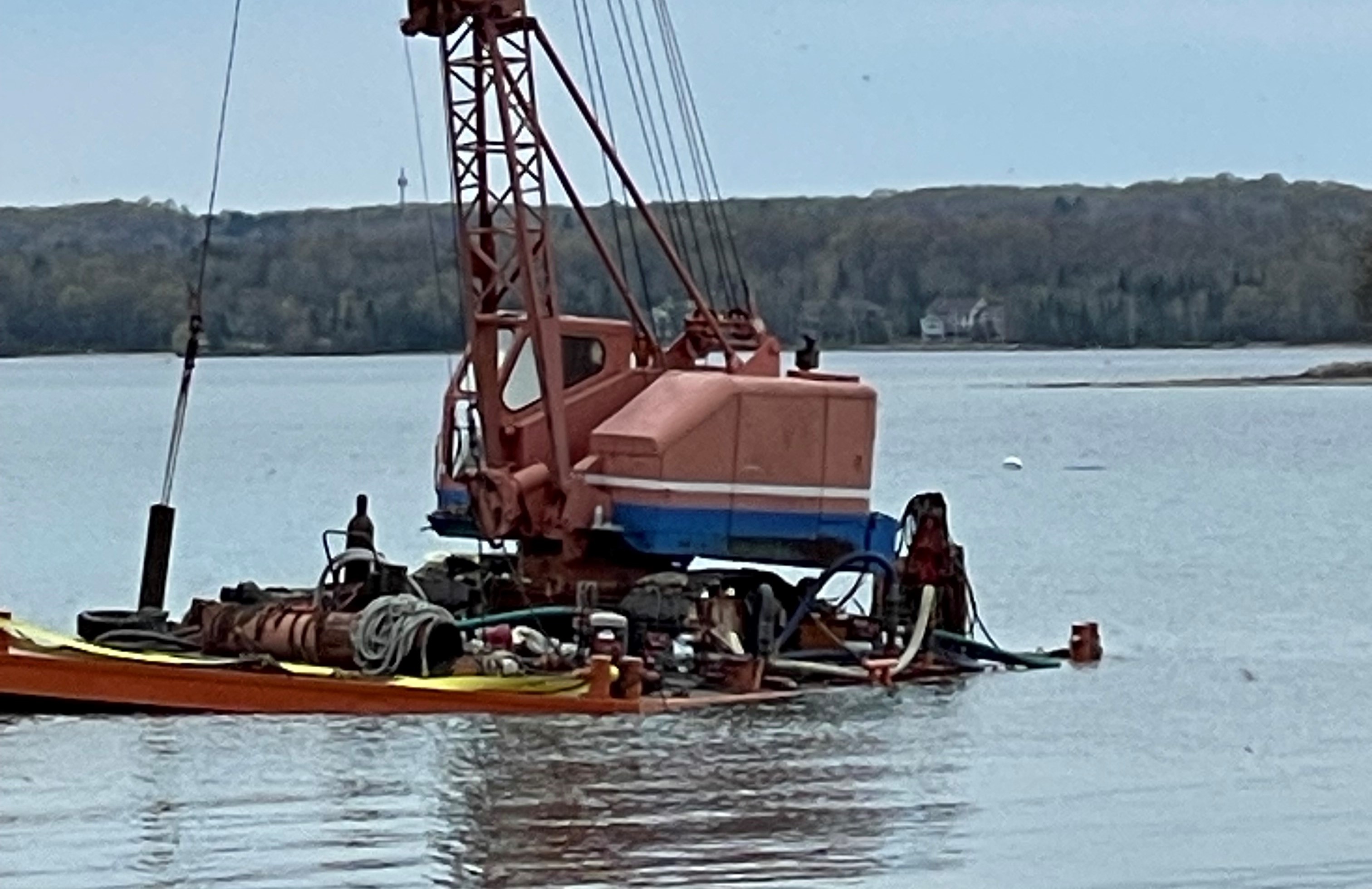 A barge owned by Balcom Marine Contractors lists in the Lake Michigan waters of Grand Traverse Bay on May 6, 2023. Listing is a nautical term for taking on water and tilting to one side.