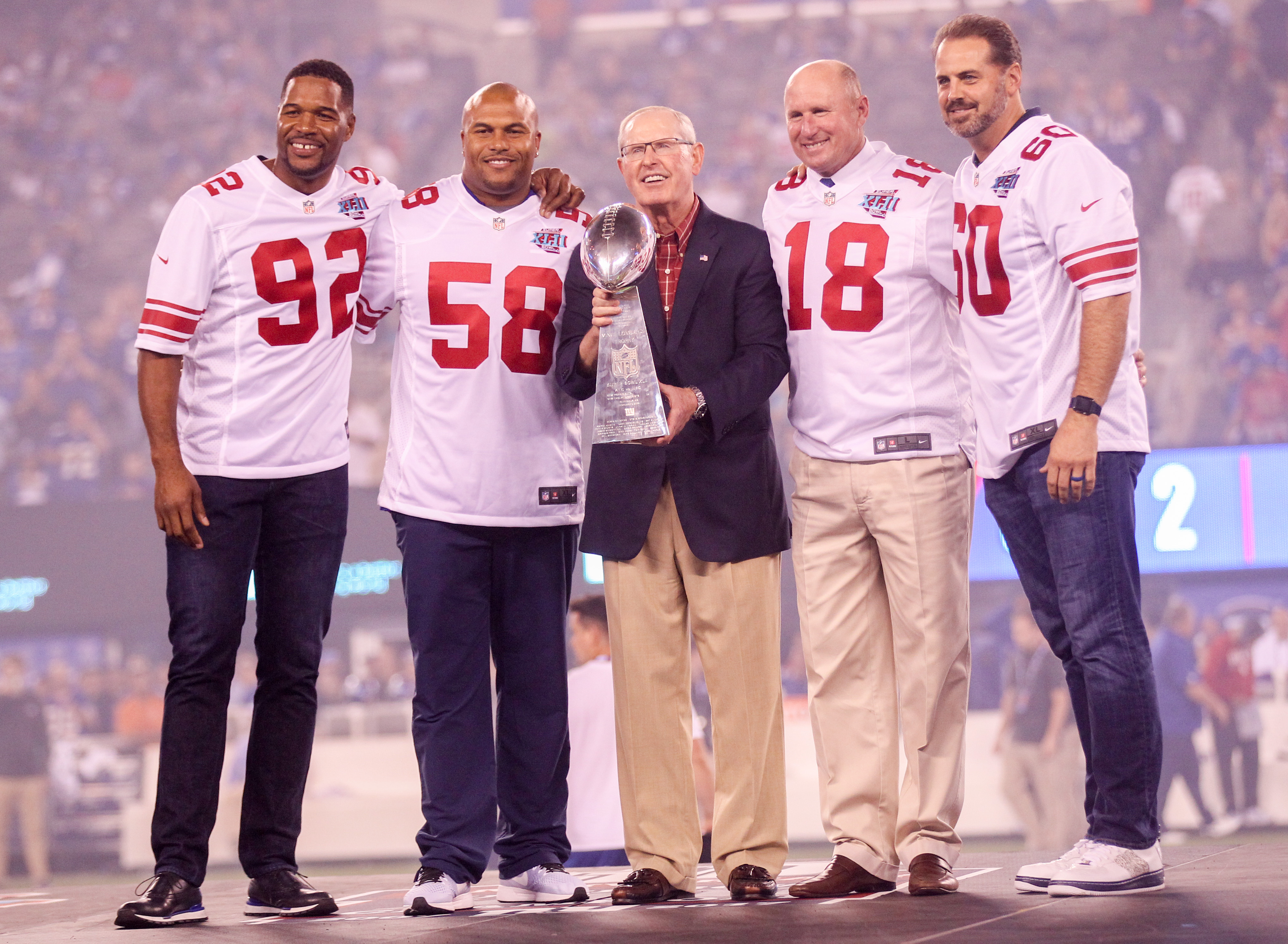 The 2007 captains of the New York Giants (l to r): Michael Strahan, Antonio Pierce, head coach Tom Coughlin, Jeff Feagles, and Shaun O'Hara take the stage with the Vince Lombardi Trophy as the Giants celebrate the 10-year anniversary of their win over the New England Patriots in Super Bowl XLII during a ceremony at halftime of the Detroit Lions game on Monday Night Football. (2017 file photo by Andrew Mills | NJ Advance Media)