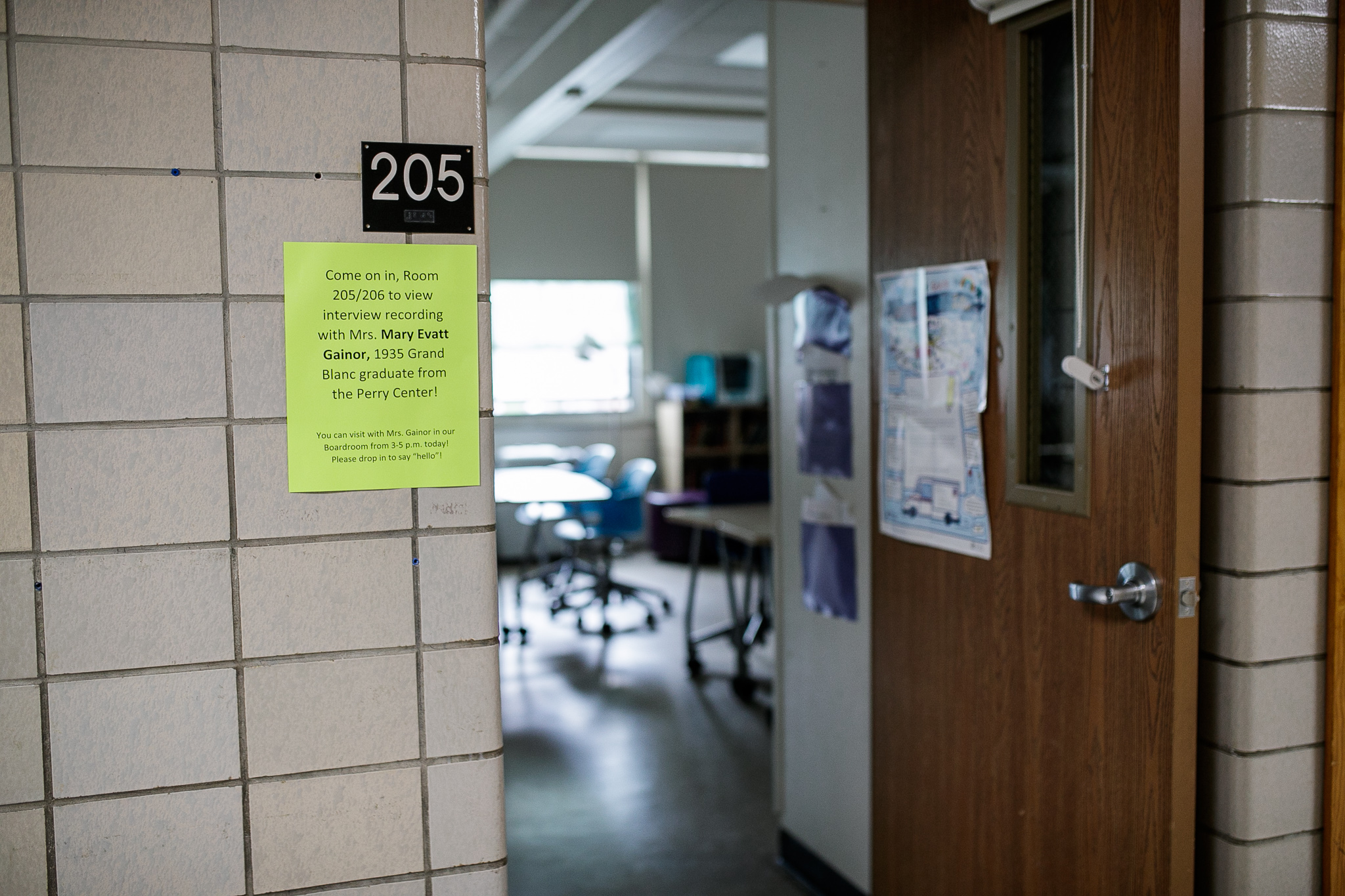Signs inviting attendants to watch videos of alumni talking about their days as student at Perry Center during the Perry Center Centennial Event in Grand Blanc on Saturday, May 14, 2022. (Jenifer Veloso | MLive.com)
