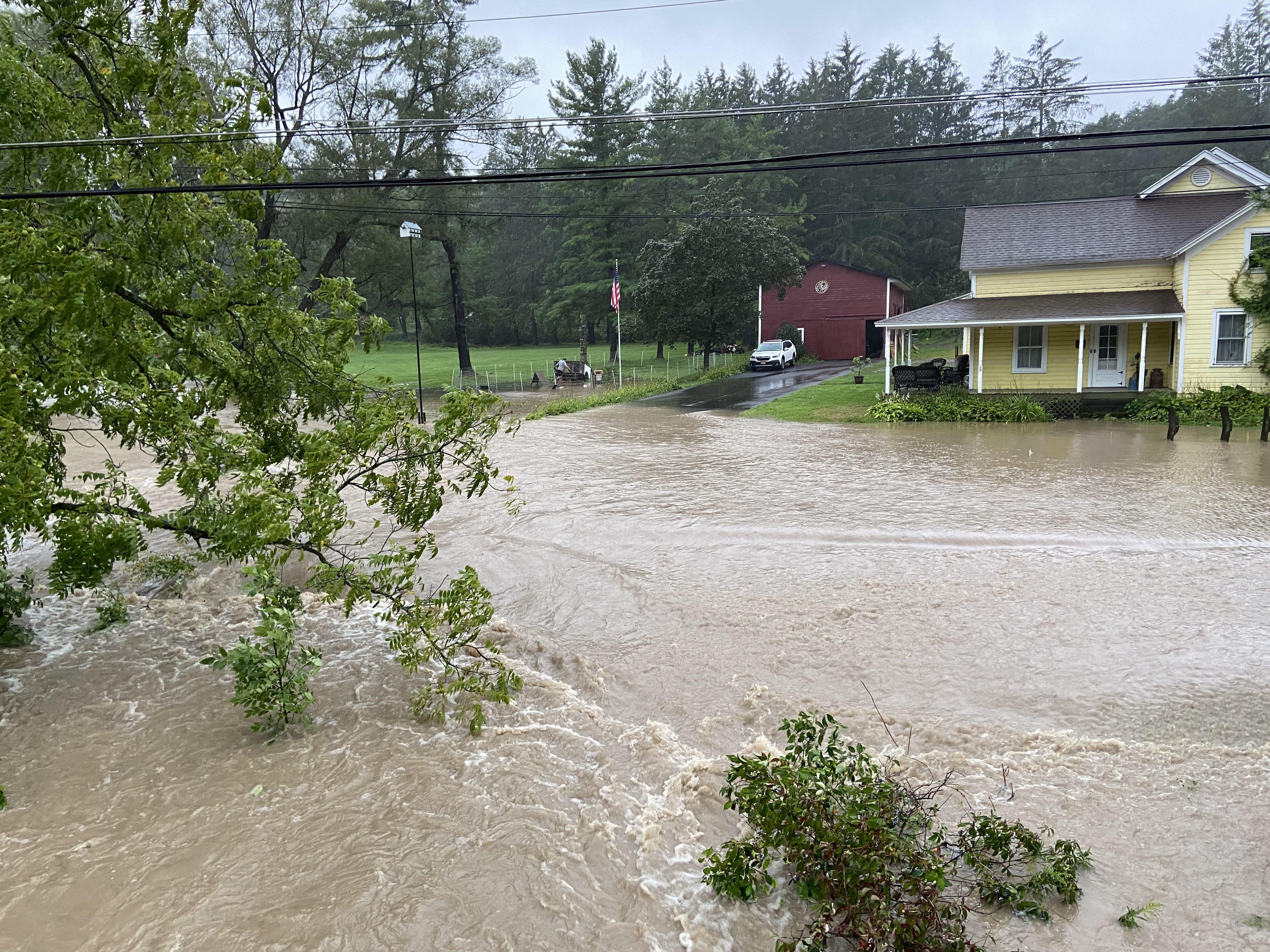Flood waters rush over South Street Road, (Route 174) near Nightengale Mills in the town of Marcellus on Thursday, Aug. 19, 2021.