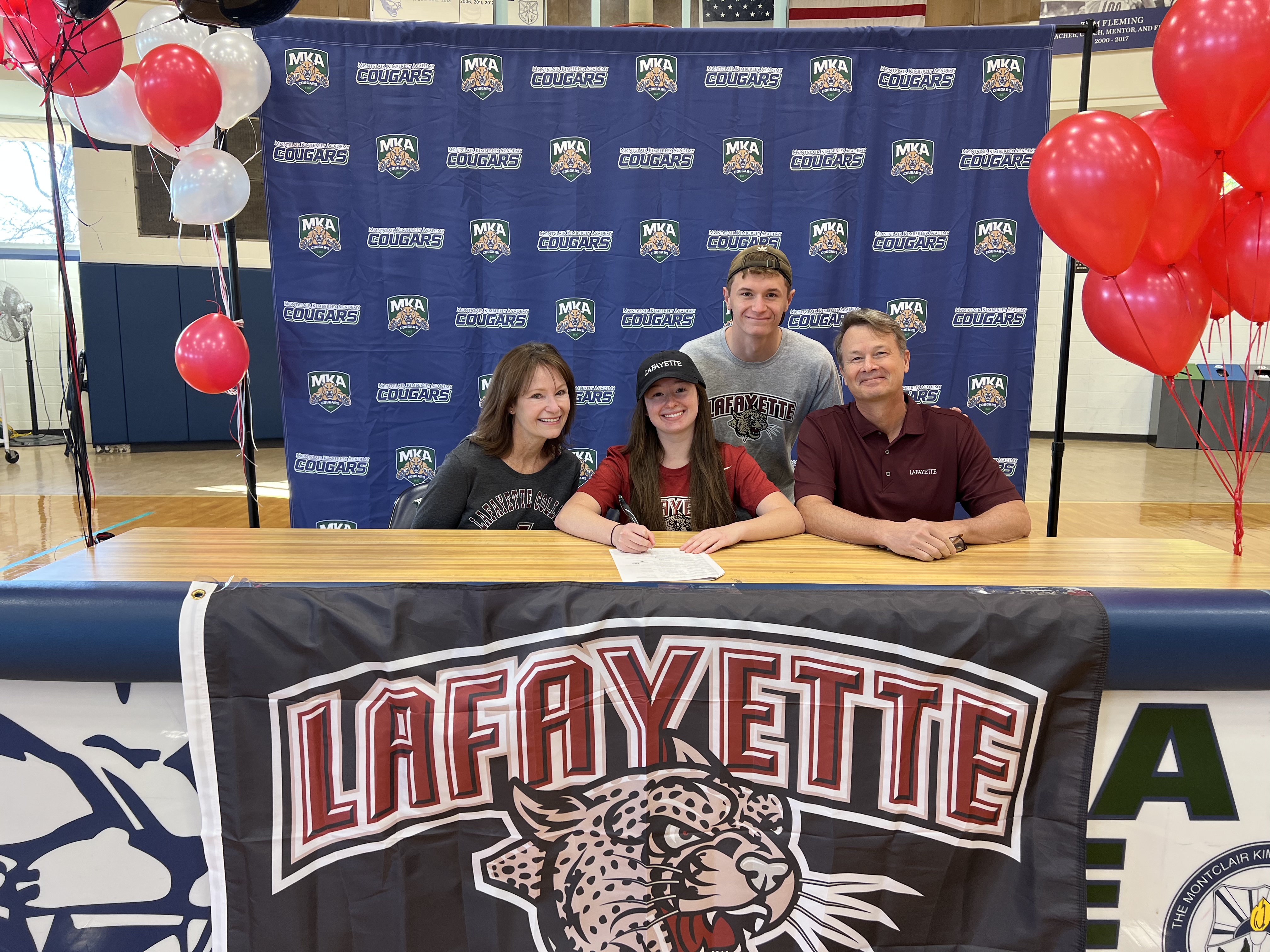 MKA swimmer Lindsay Driever signs her NLI to Lafayette with her parents and twin brother