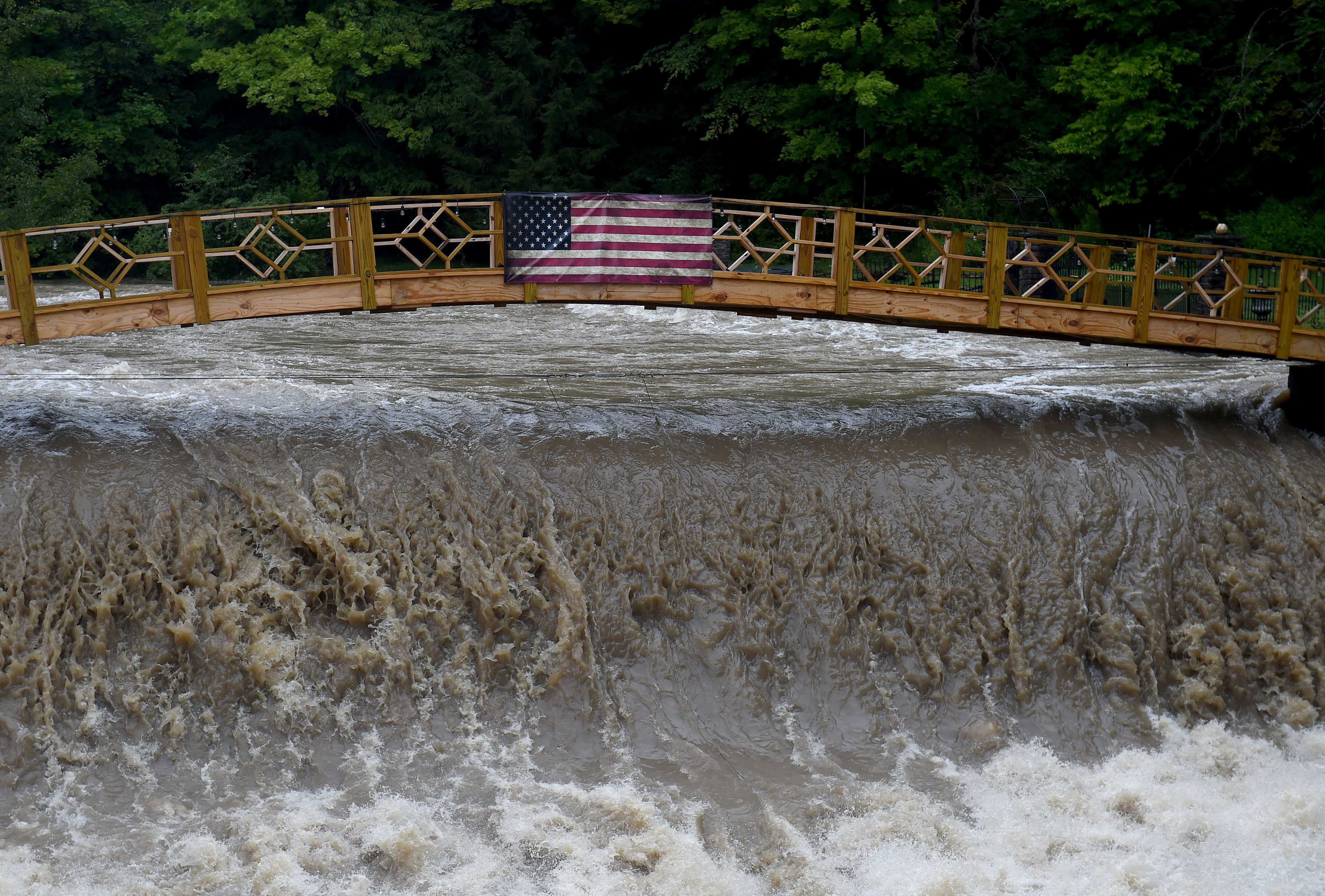 The flow of Ninemile Creek after heavy rain nearly touches the bridge for one home owner August 19, 2021.  Dennis Nett | dnett@syracuse.com